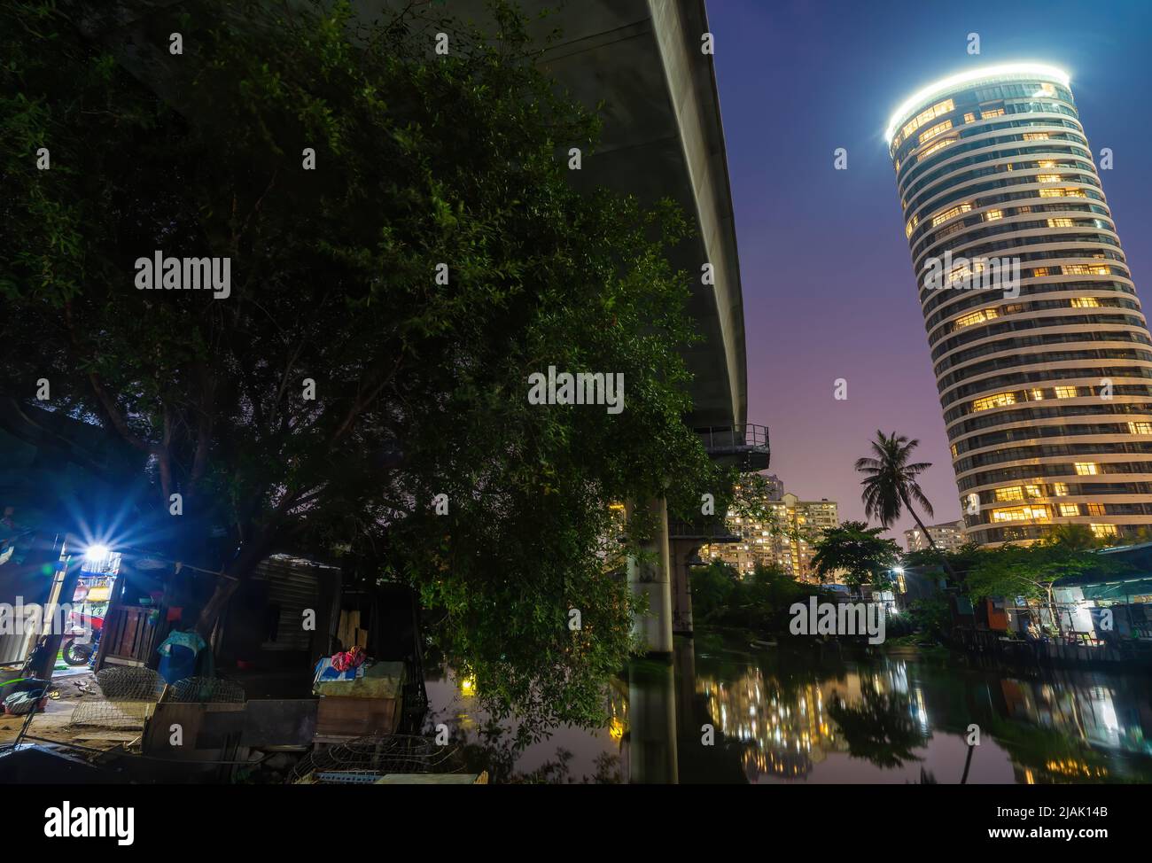 Una scena di contrasto tra nuovi edifici moderni e baraccopoli in paesi in via di sviluppo come il Vietnam. Un paesaggio rappresenta un riflesso tra ricco e poo Foto Stock