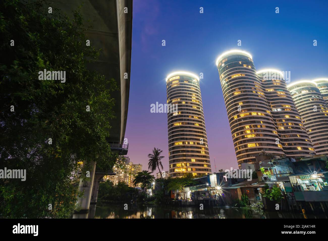 Una scena di contrasto tra nuovi edifici moderni e baraccopoli in paesi in via di sviluppo come il Vietnam. Un paesaggio rappresenta un riflesso tra ricco e poo Foto Stock