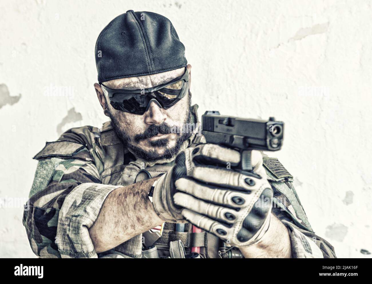 Soldato in testa di baseball indietro sparando la sua pistola. Foto Stock