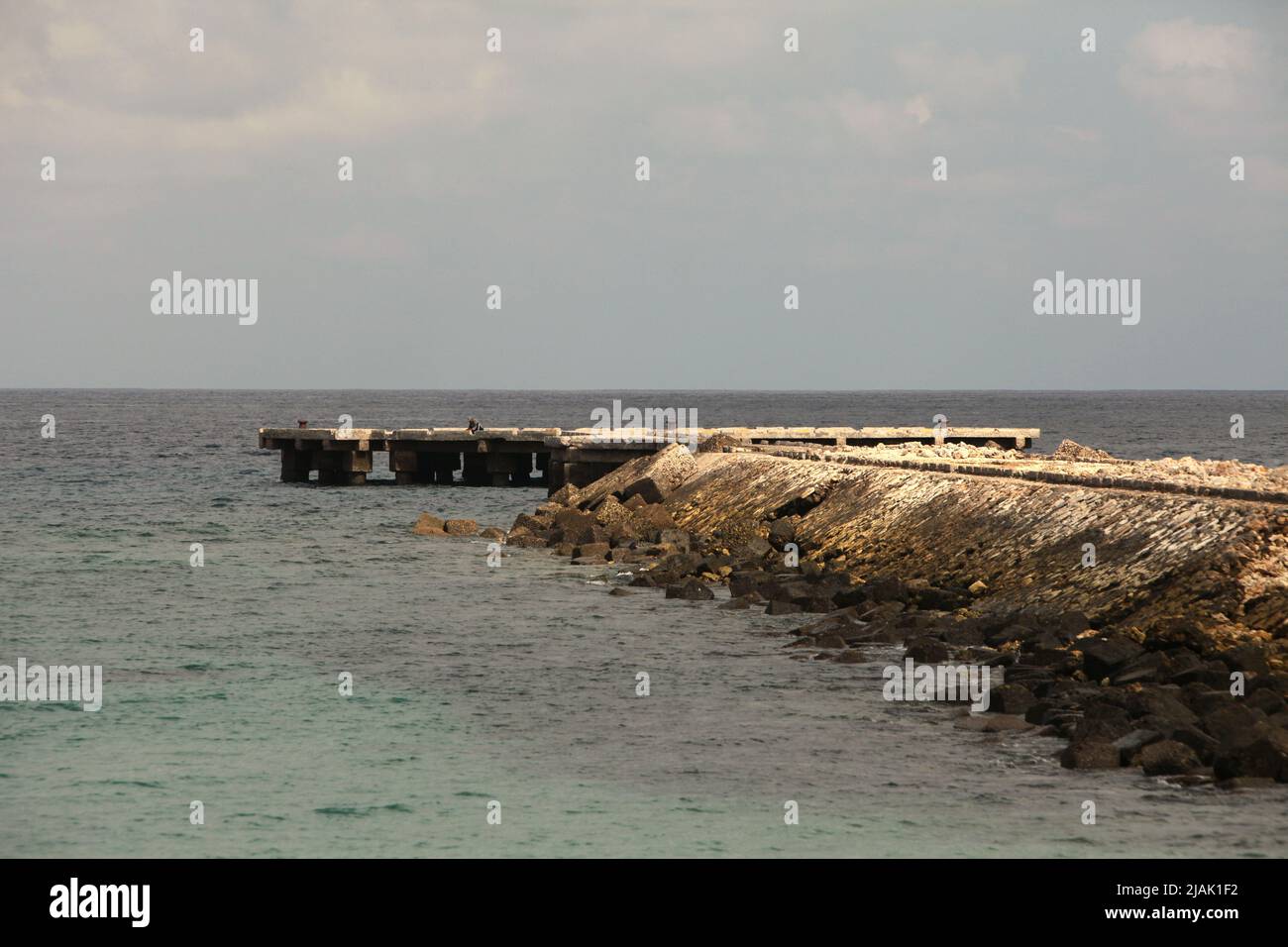 Un molo abbandonato di fronte all'Oceano Indiano, fotografato durante la stagione secca a Rua, Isola di Sumba, Nusa Tenggara Est, Indonesia. Foto Stock
