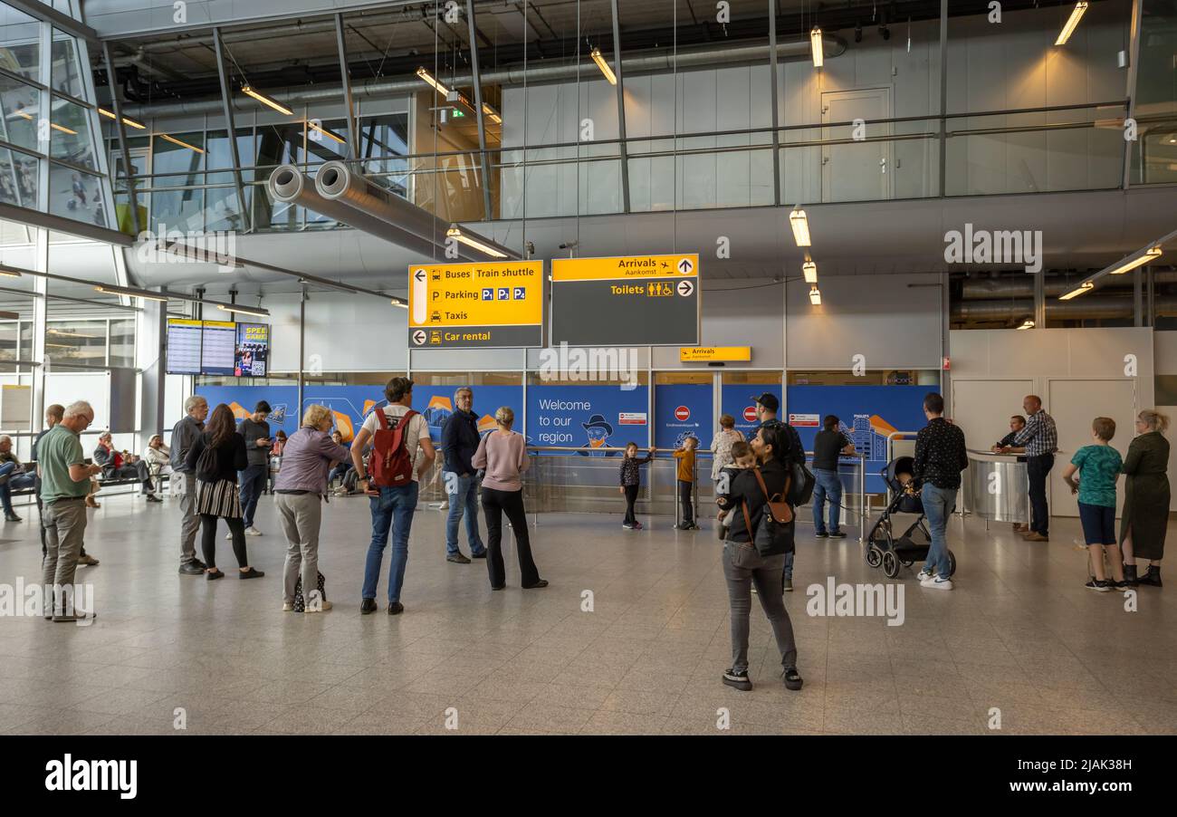 Persone all'aeroporto di Eindhoven in attesa che i passeggeri arrivino alla sala degli arrivi Foto Stock