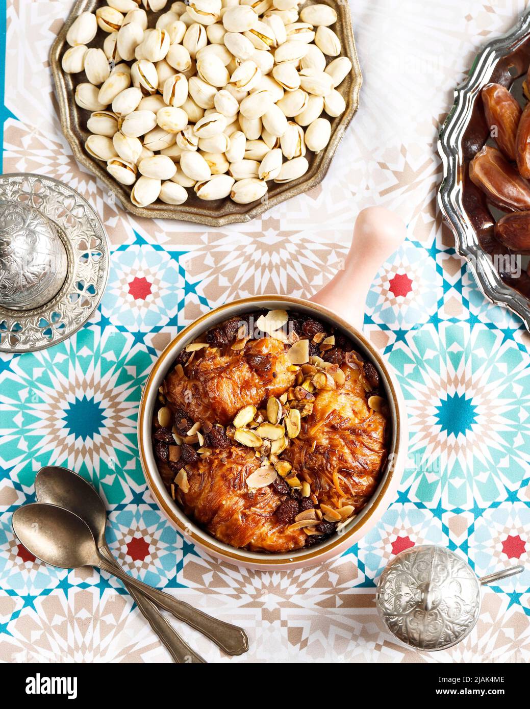 Cucina araba, tradizionale dessert egiziano Om Ali o Umm Ali. Pane ammollato, latte, e carico di noci arrosto, e uvetta. Vista superiore, fuoco selezionato Foto Stock