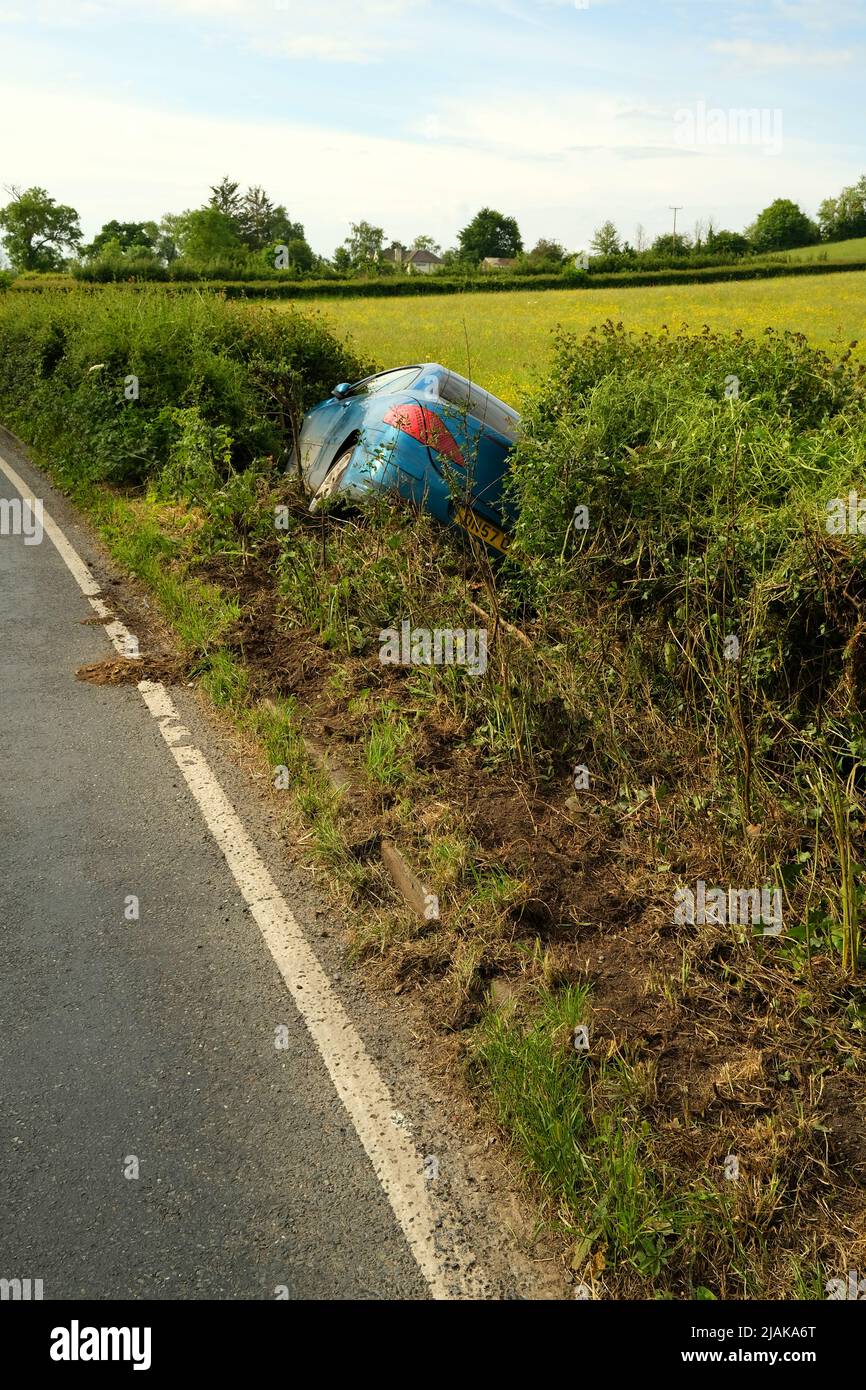 2022 maggio - Peugeot auto in un fosso accanto a una strada rurale prima cosa al mattino dopo un fine settimana, possibile bere guida, Foto Stock