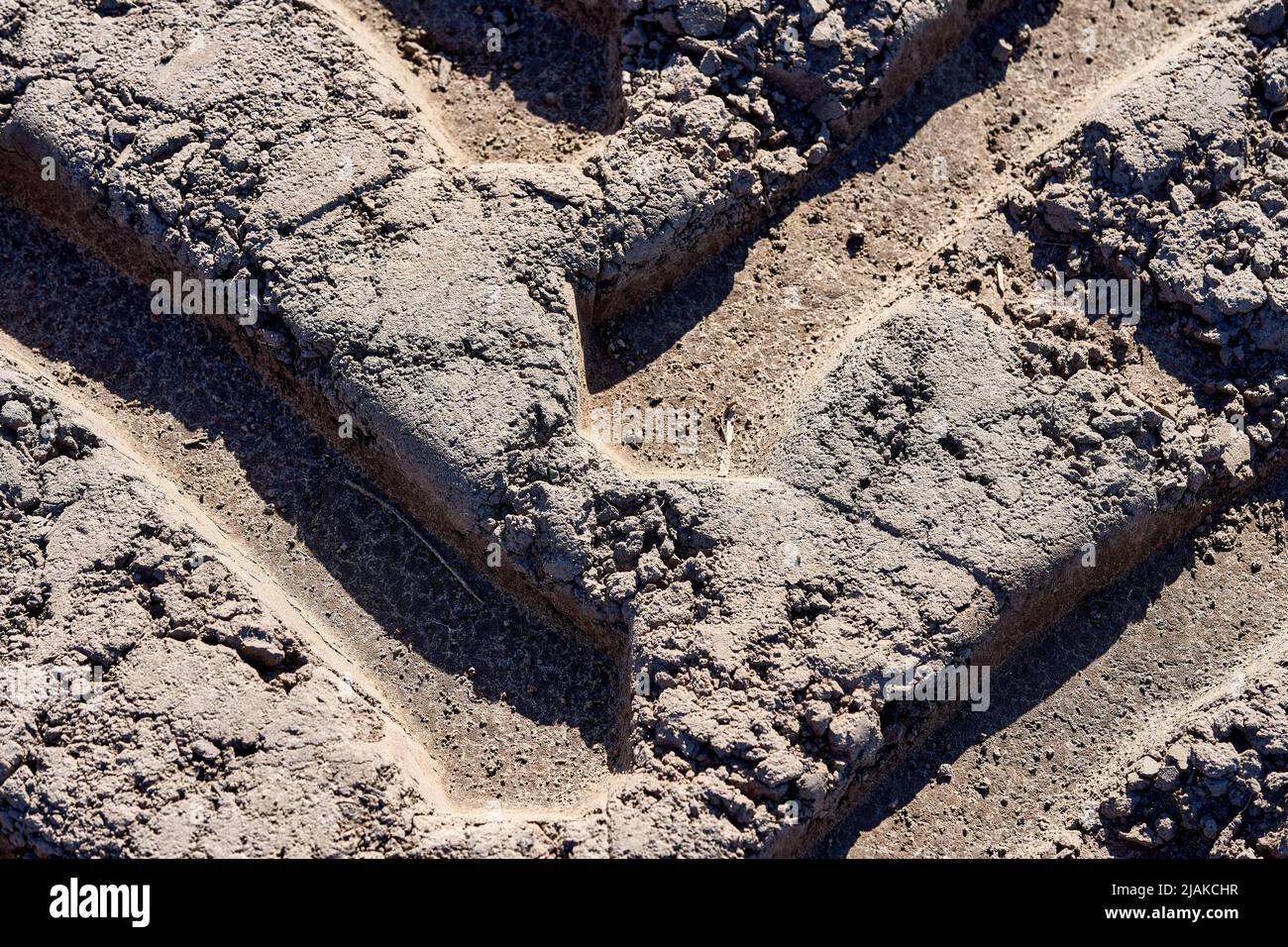 Primo piano del cingolo del trattore nel campo di aratura Foto Stock