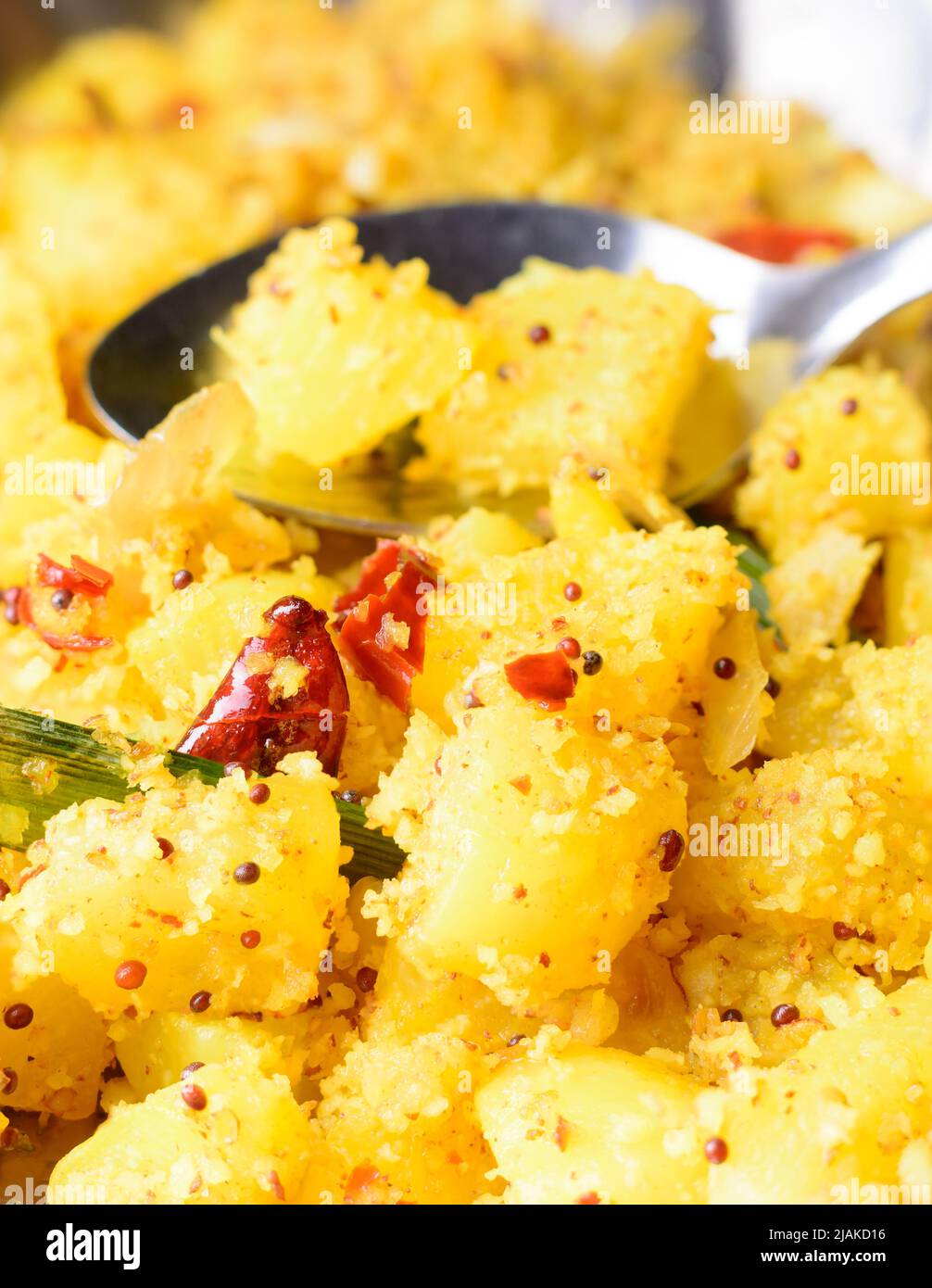 piatto di rafano cotto con cocco grattugiato, curry vegetariano temperato sano con semi di senape, vista closeup con un cucchiaio sullo sfondo Foto Stock