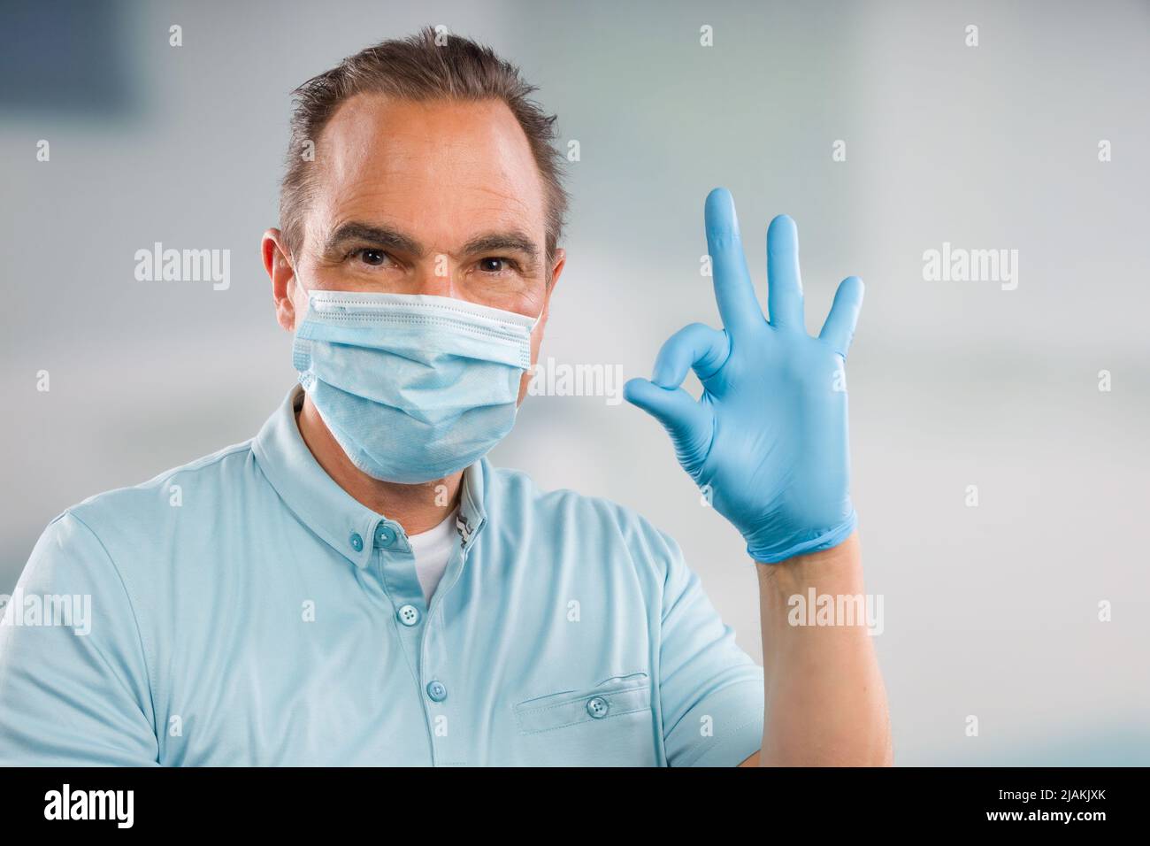 Medico con maschera medica e guanti medici mostra tutto è OK Foto Stock