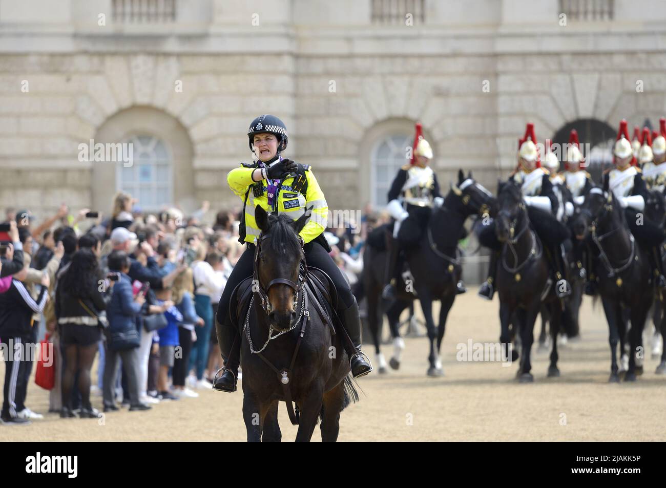 Londra, Inghilterra, Regno Unito. Ufficiale di polizia montato femminile che dirige il pubblico durante il Cambio della Guardia nella Parata delle Guardie del Cavallo Foto Stock