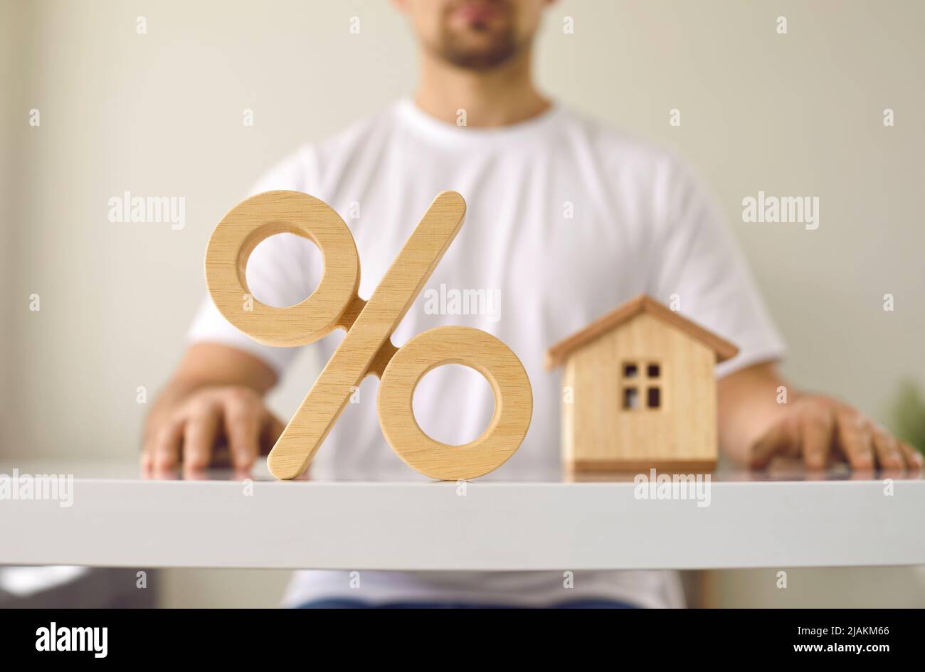 Segno di percentuale, uomo e casa che illustrano i tassi di interesse ipotecari e concetto di bene immobile Foto Stock