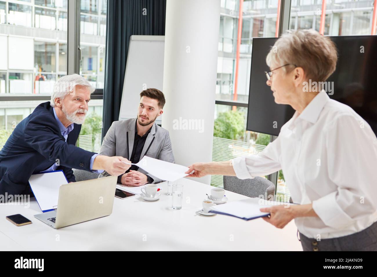 La donna di affari presenta il contratto al socio di affari dopo la negoziazione riuscita Foto Stock