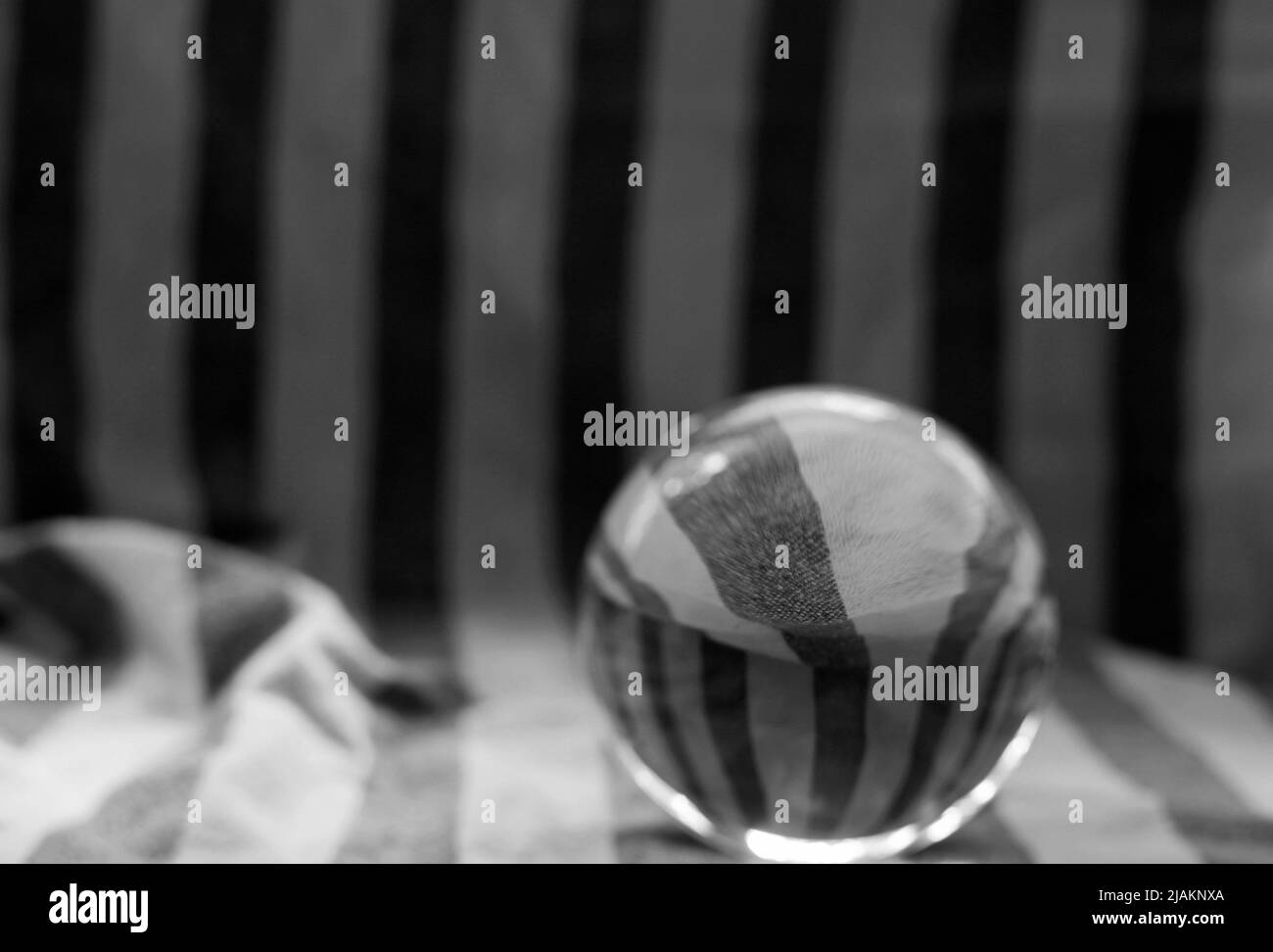 primo piano di una sfera di lente di vetro su uno sfondo di tessuto Foto Stock