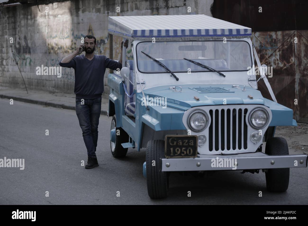 Un uomo di 45 anni di Gaza possiede un'auto vecchia risalente al 1950 Foto Stock