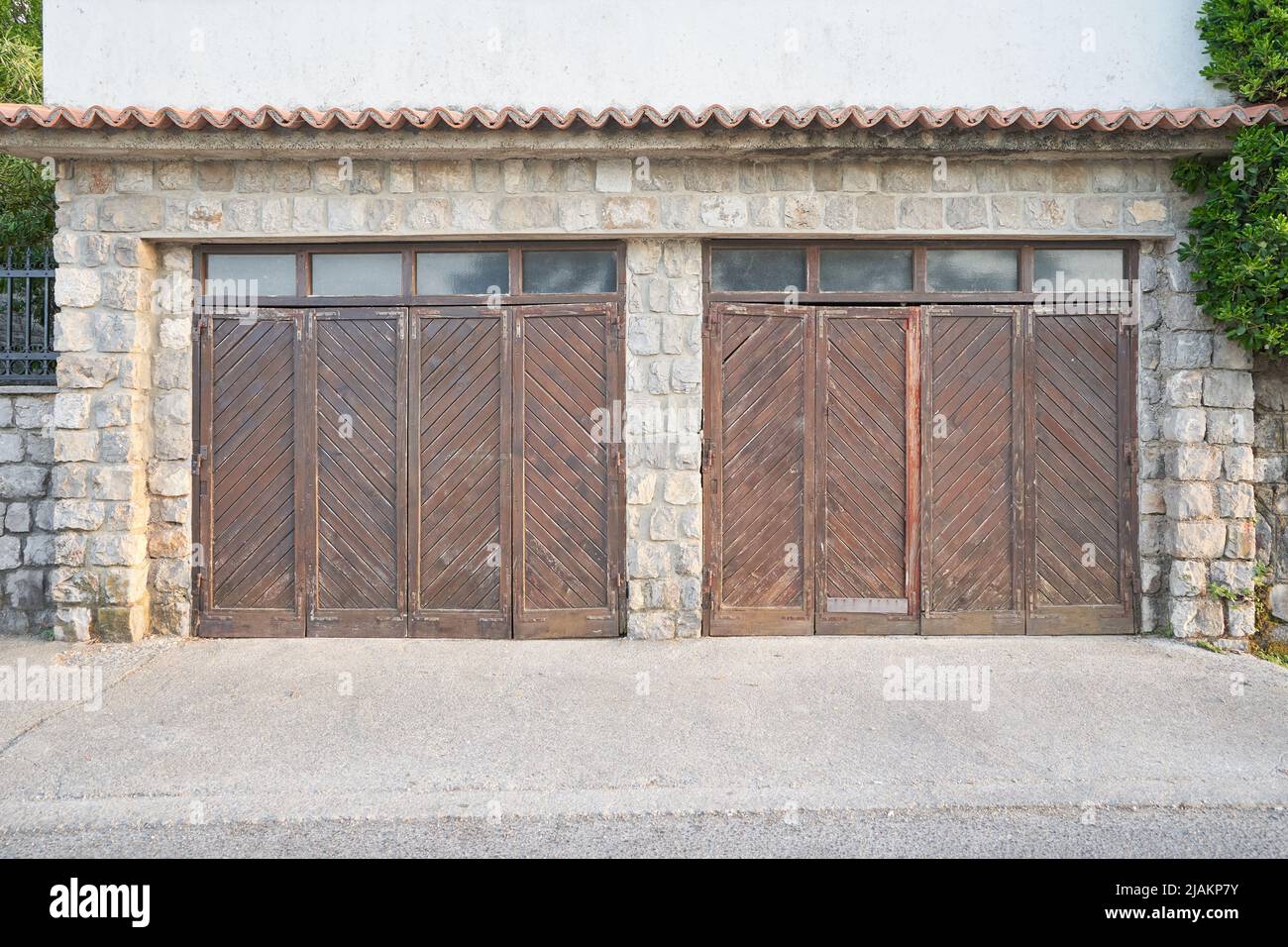 Vecchio garage con cancelli in legno shabby per due auto Foto Stock
