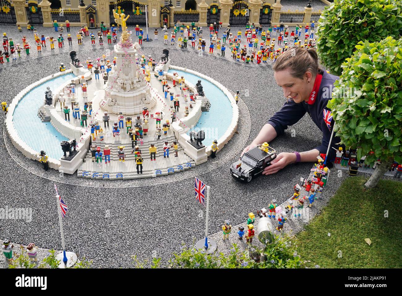 Model Maker Freya Groom colloca una replica della Regina Elisabetta II, riimmaginata in mattoni LEGO, in un veicolo animato come parte del Platinum Jubilee Display presentato oggi al LEGOLAND Windsor Resort. La regina animata e il veicolo ha preso 15hrs per costruire utilizzando 1.350 mattoni. LEGOLAND Windsor Resort ha presentato oggi i suoi modelli di ispirazione regale per celebrare il Giubileo del platino della Regina. Il numero complessivo di mattoni utilizzati è stato di 18.001 e i modelli hanno impiegato un totale di 281,5 ore per finire. Il display include anche una festa di strada e scena pic-nic, così come le versioni in miniatura dei reali, l'albero di Foto Stock