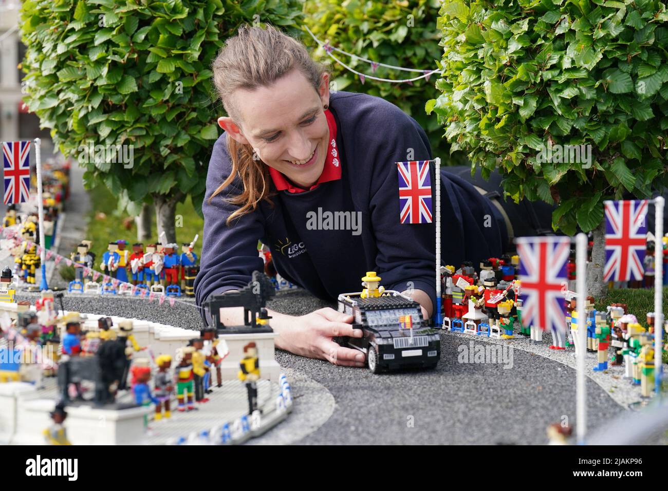 Model Maker Freya Groom colloca una replica della Regina Elisabetta II, riimmaginata in mattoni LEGO, in un veicolo animato come parte del Platinum Jubilee Display presentato oggi al LEGOLAND Windsor Resort. La regina animata e il veicolo ha preso 15hrs per costruire utilizzando 1.350 mattoni. LEGOLAND Windsor Resort ha presentato oggi i suoi modelli di ispirazione regale per celebrare il Giubileo del platino della Regina. Il numero complessivo di mattoni utilizzati è stato di 18.001 e i modelli hanno impiegato un totale di 281,5 ore per finire. Il display include anche una festa di strada e scena pic-nic, così come le versioni in miniatura dei reali, l'albero di Foto Stock