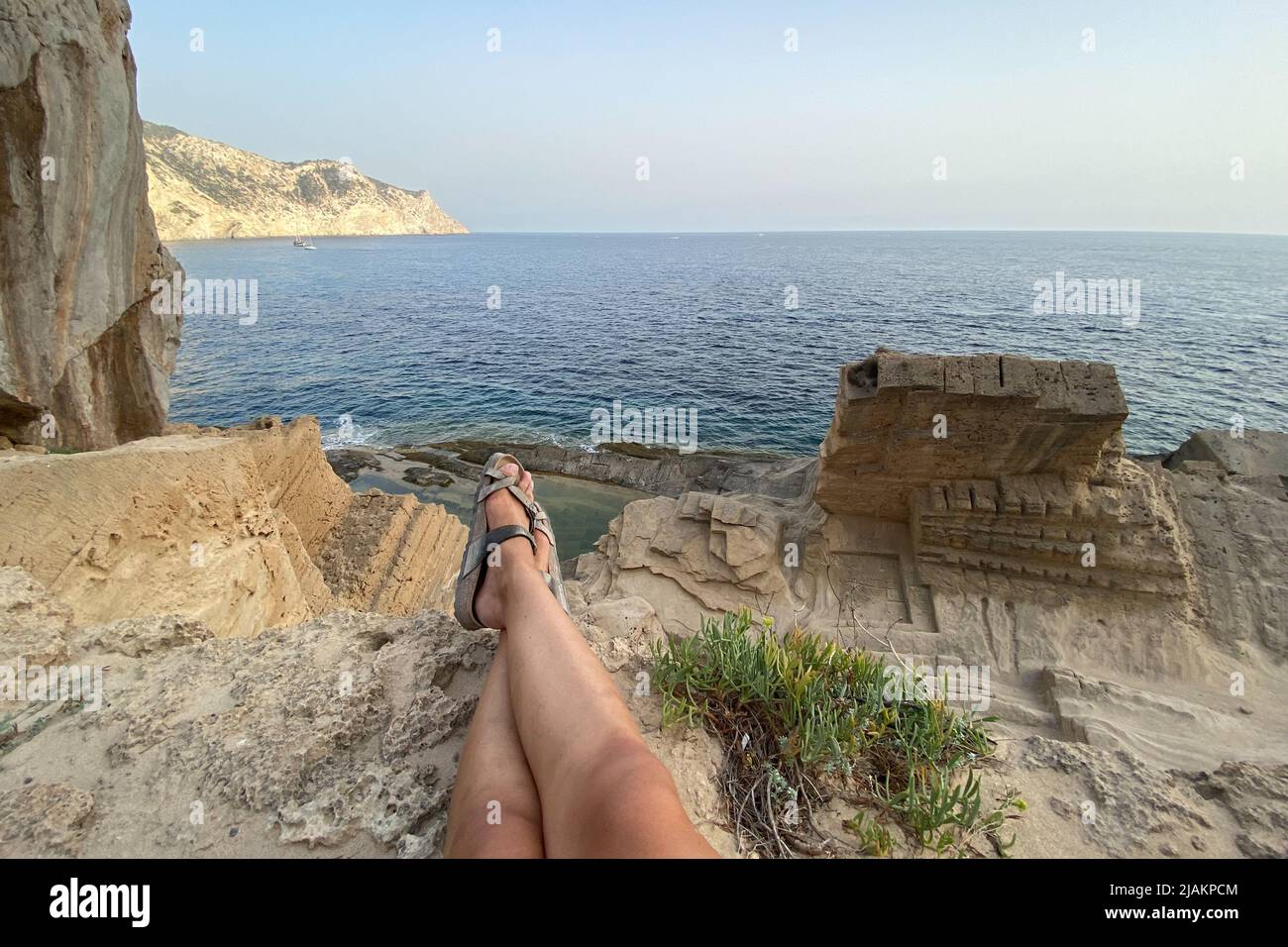 Gambe di una donna sulla spiaggia di Atlantis sull'isola di Ibiza Foto Stock