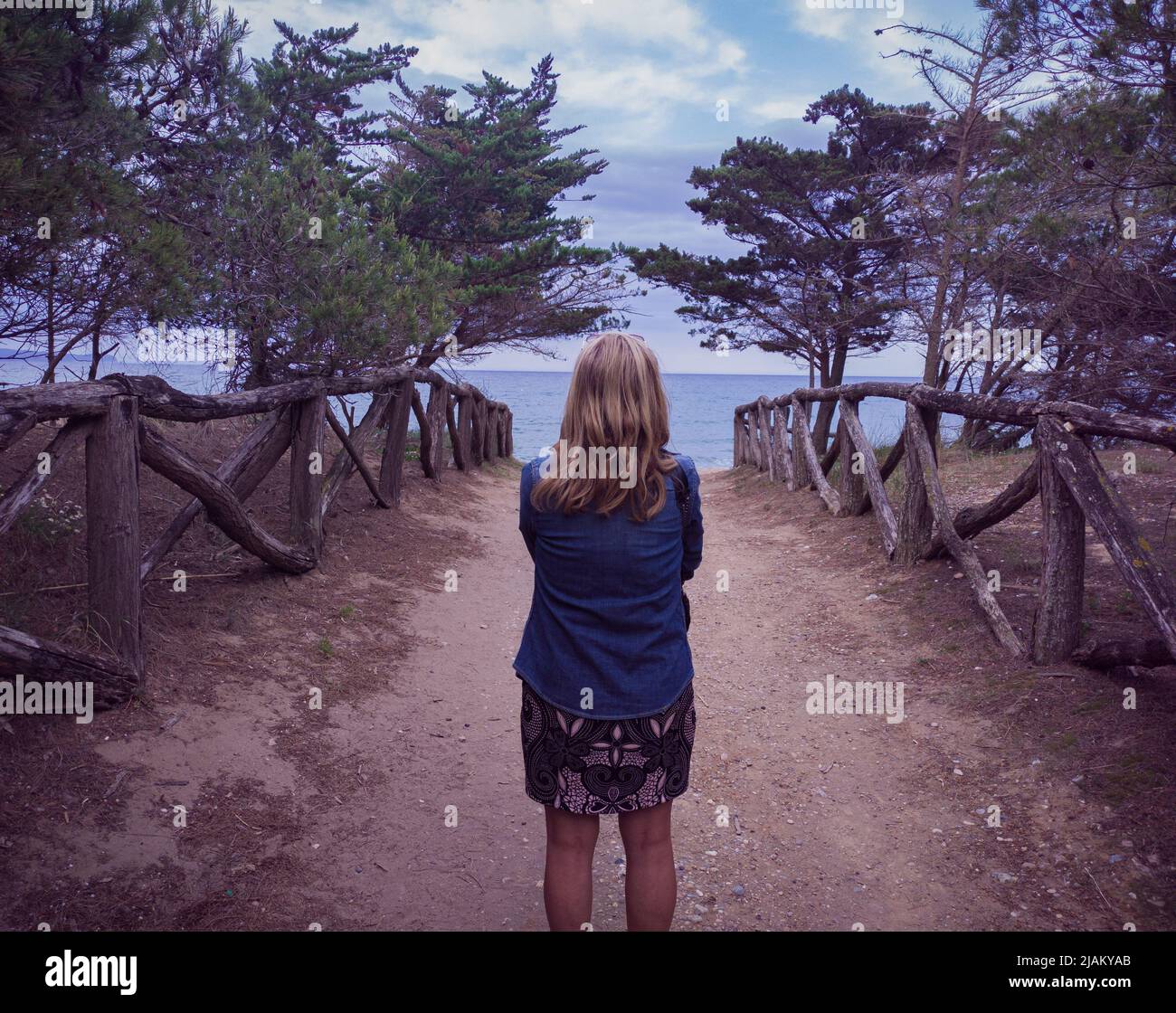 Signora sulla schiena guardando il mare su una strada costiera a Girona. Foto Stock