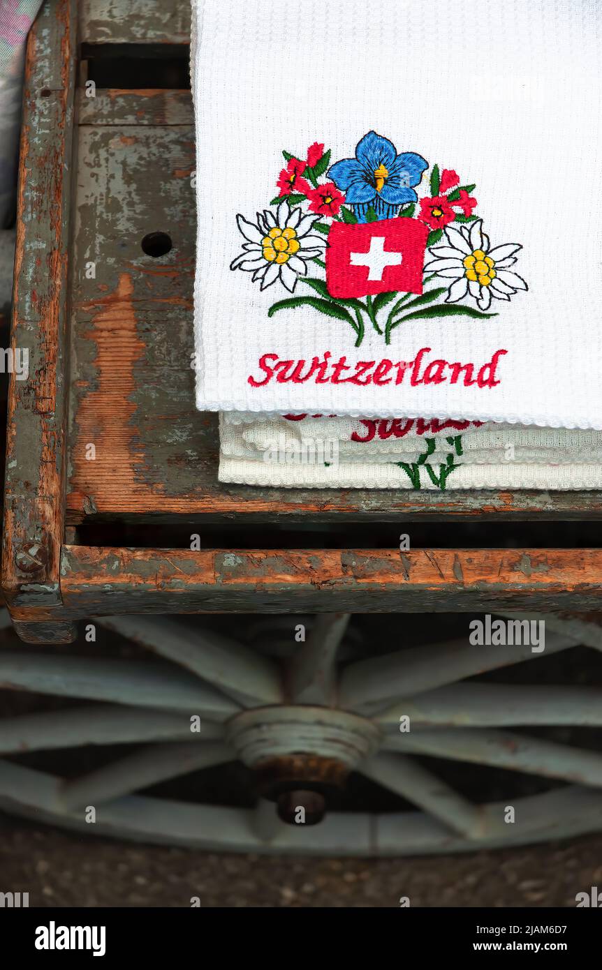 Appenzell, Svizzera - 27 maggio 2022: Tovagliolo ricamato con un motivo di fiori alpini e l'iscrizione Svizzera su un antico legno Foto Stock