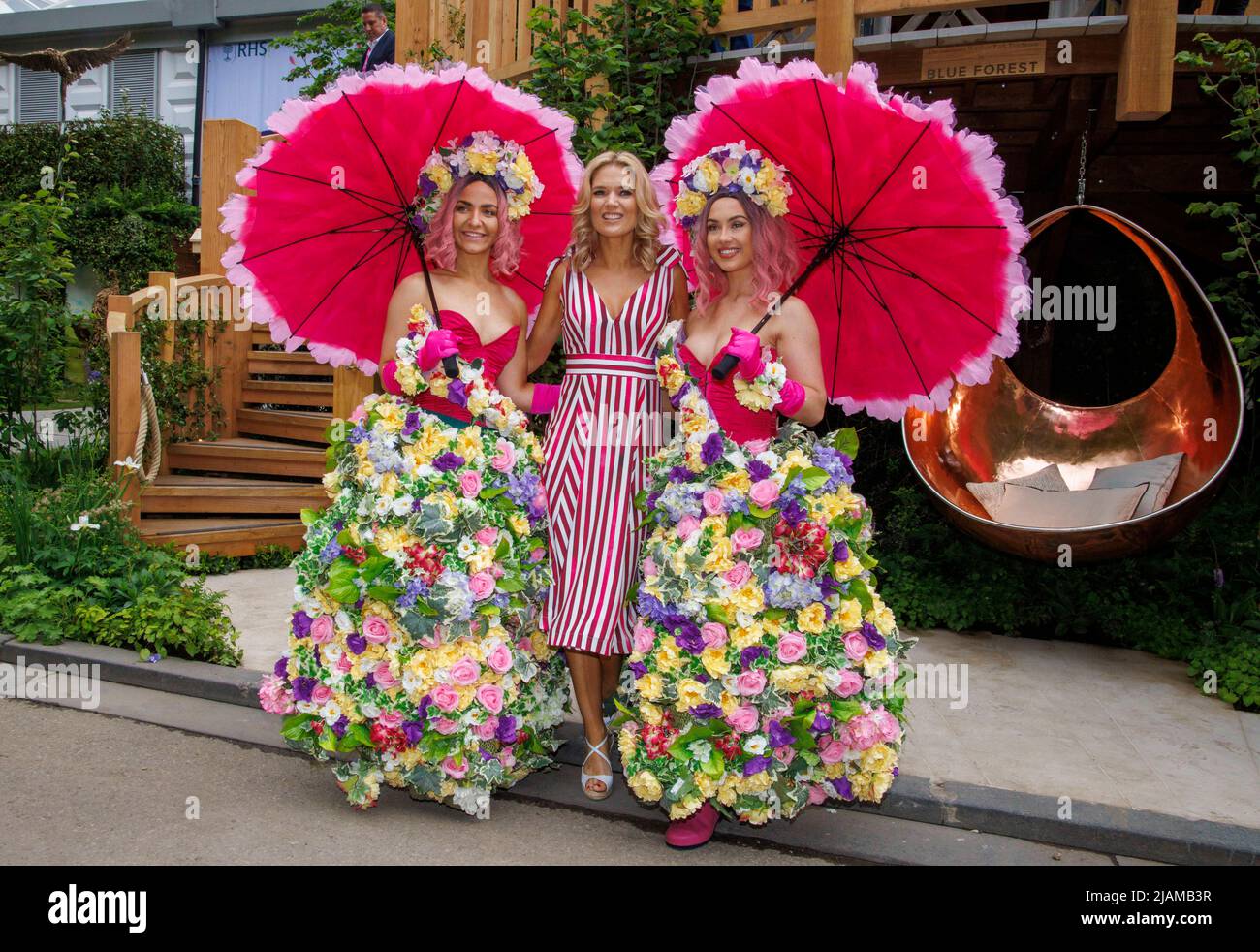 Charlotte Hawkins, presentatore televisivo, newsreader e giornalista, al RHS Chelsea Flower Show con due modelli in abiti floreali. Foto Stock