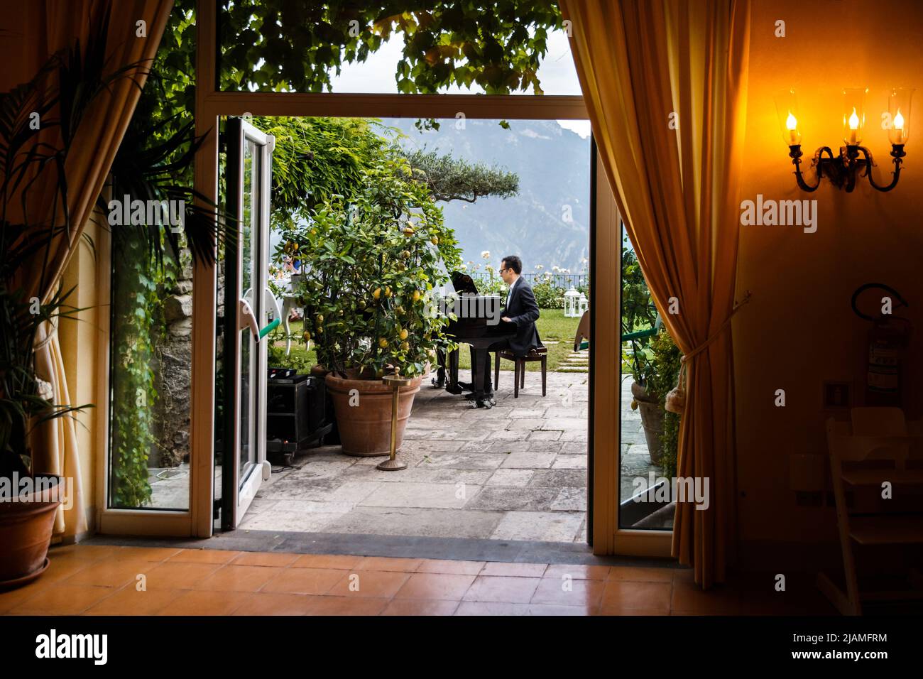 Il pianista suona in un matrimonio in giardino. Foto Stock
