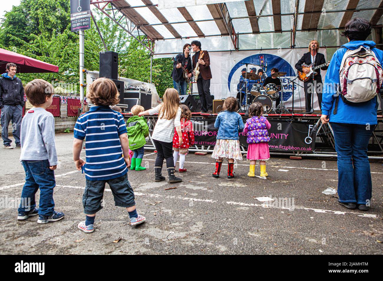 UK, Greater London, St Margarets - 3nd Giugno 2012: Festa del Giubileo del Diamante Regina Elisabetta II con un mercato di strada e musica dal vivo, i bambini che si godono la musica dal vivo al party di strada Foto Stock