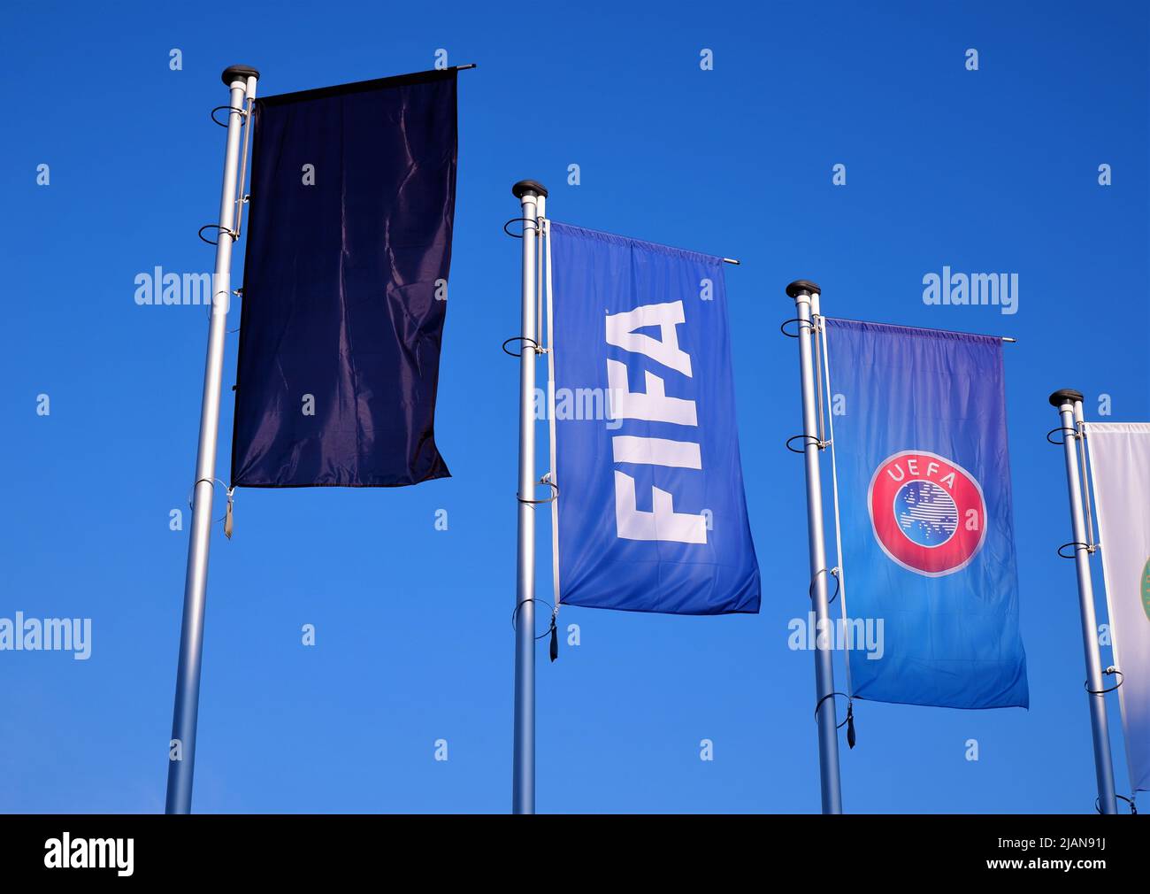 Bandiera di lutto nero per la guerra in Ucraina, bandiere FIFA e UEFA di fronte alla costruzione dell'Associazione di calcio ungherese con backgroun cielo blu Foto Stock