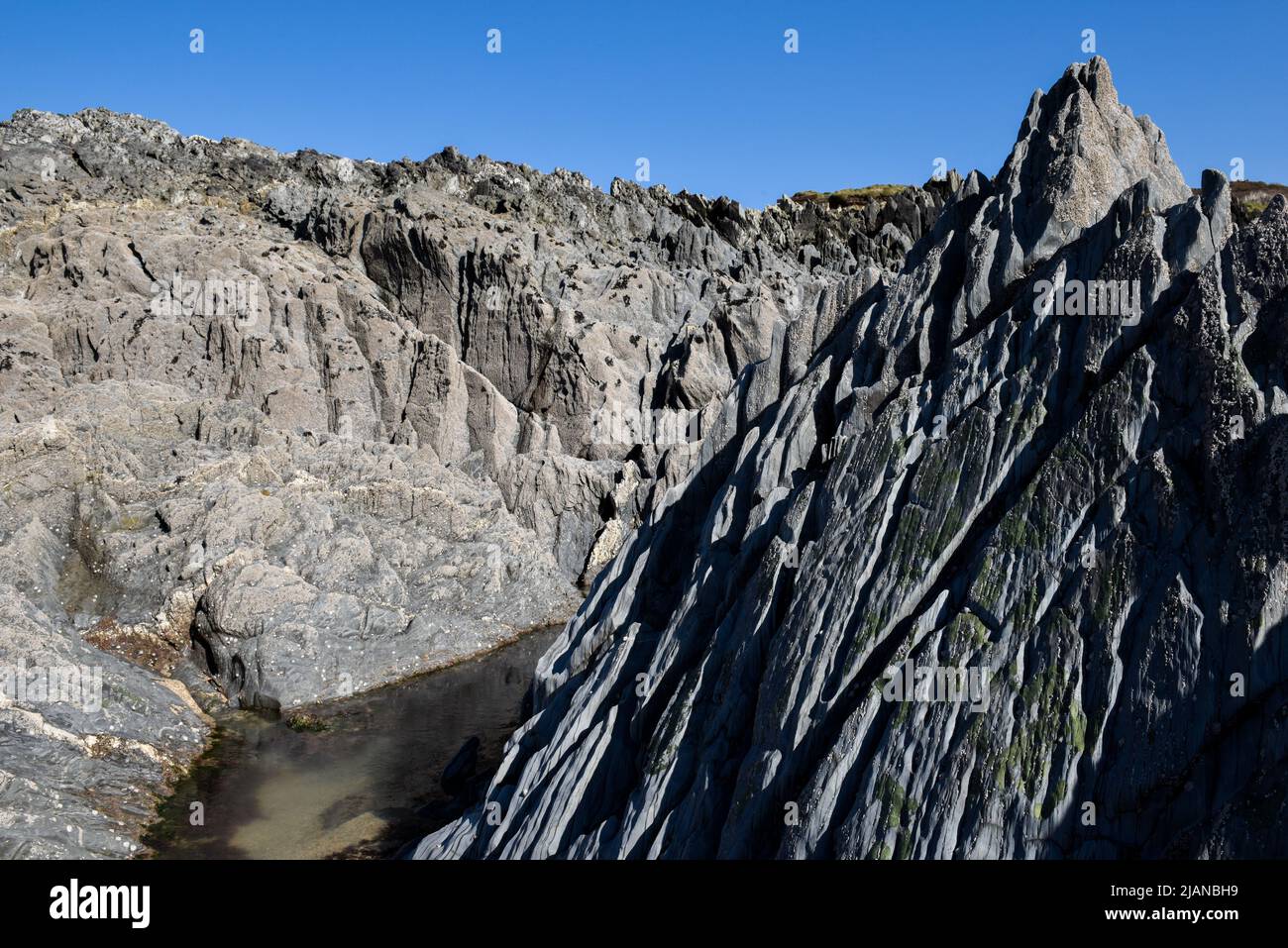 Formazione di roccia naturale zona costiera con piscine di roccia lasciate dalla bassa marea Foto Stock