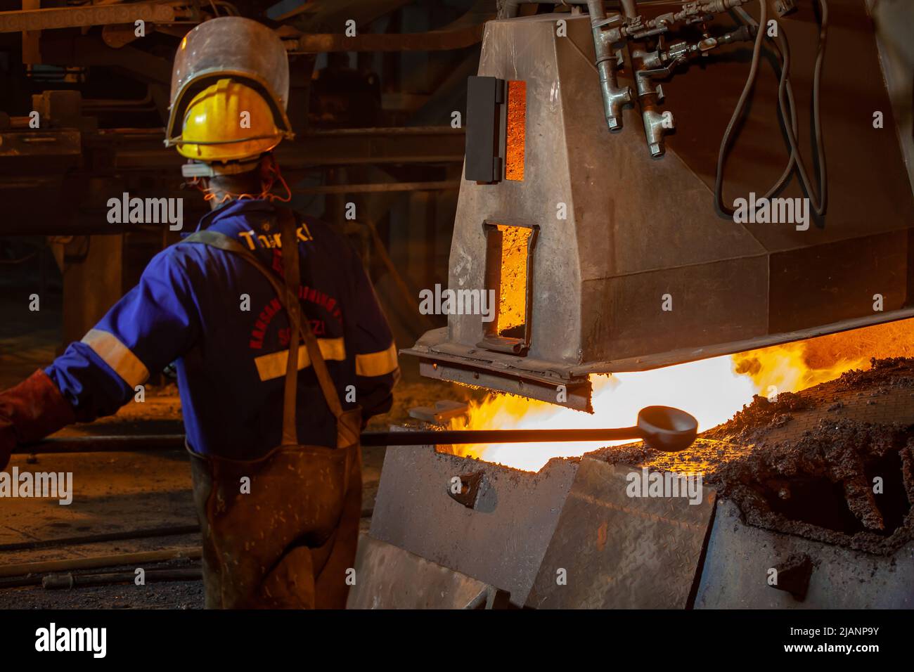 Uomo con crogiolo a manico lungo, prima fonderia di rame dei minerali Quantum Foto Stock