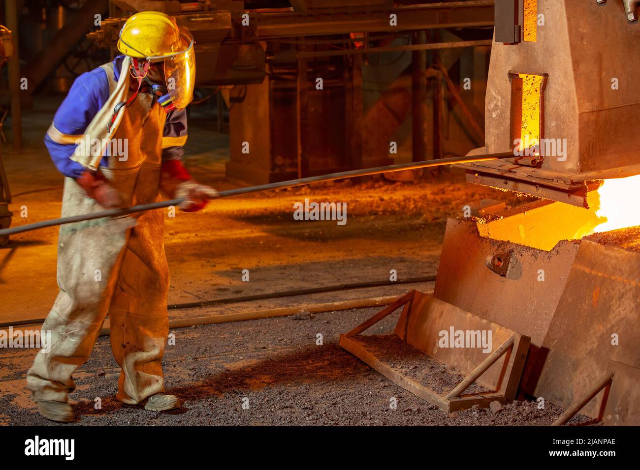 Uomo con crogiolo a manico lungo, prima fonderia di rame dei minerali Quantum Foto Stock