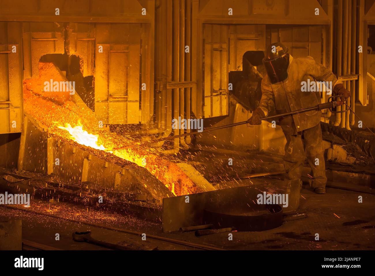 Uomo che mantiene il flusso di rame fuso, prima fonderia di rame Quantum Minerals Foto Stock