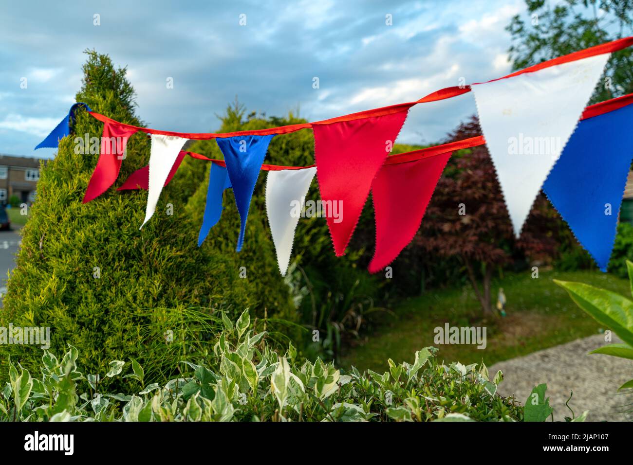 Bandiere mungenti in colori di bandiera britannica, bianco, rosso e blu, ciascuna in colori diversi. Bandiere triangolari colorate che soffiano nel vento per celebrare il Foto Stock