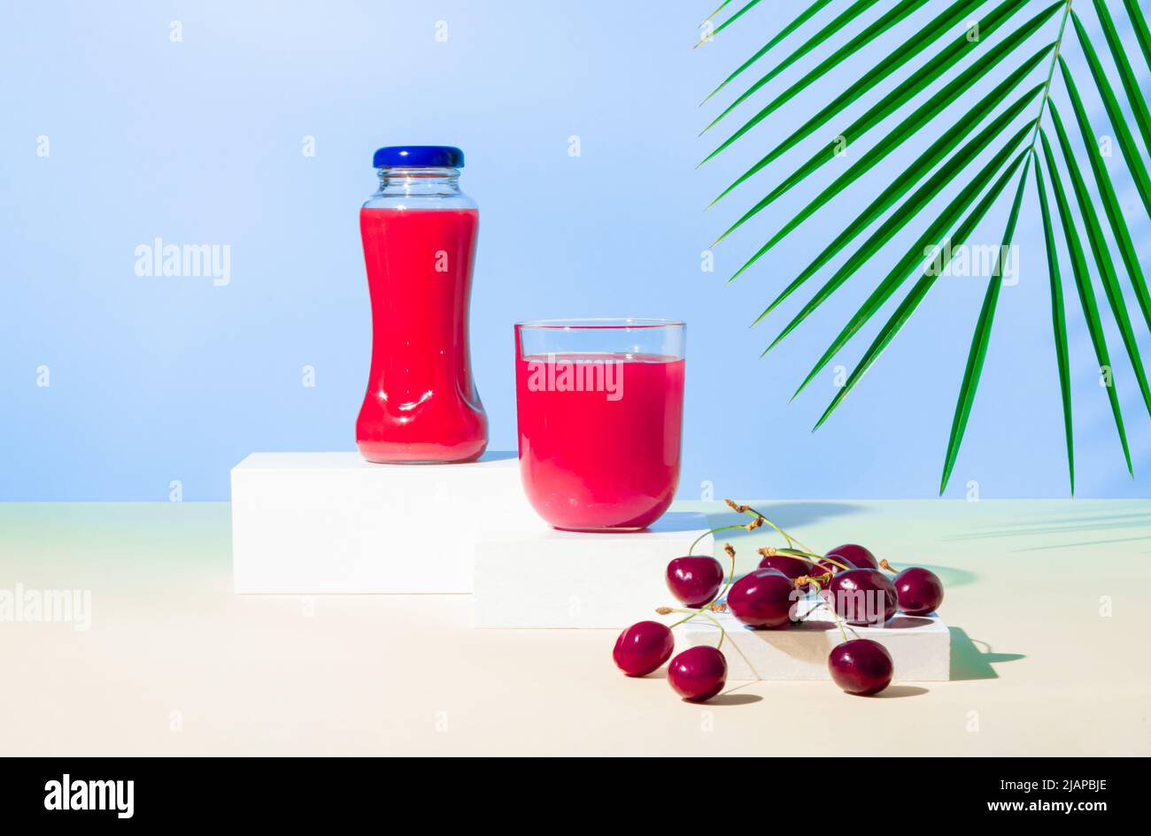 Concetto di vita sana con frutta fresca e matura al ciliegia sul podio o piedistallo con foglia di palma tropicale. Dieta minima di disintossicazione o idea di estate. Foto Stock Concetto di vita sana con frutta fresca e matura al ciliegia sul podio o piedistallo con foglia di palma tropicale. Dieta minima di disintossicazione o idea di estate. Foto Stock