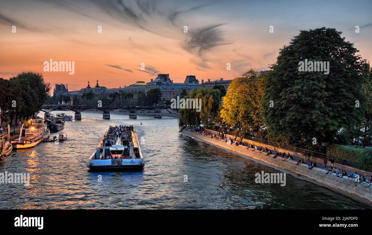 Bateaux Mouches sulla Senna, Parigi, Francia. Tour in barca che naviga su e giù per la Senna, illuminando i punti di riferimento con potenti alluvione. Immagine tratta dal Pont Neuf che mostra la Galerie du Vert Galant alla punta del ële de la CitŽ. Foto Stock