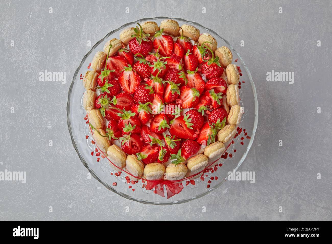 Dessert con fragole, biscotti savoiardi e mascarpone legati con un nastro rosso Foto Stock