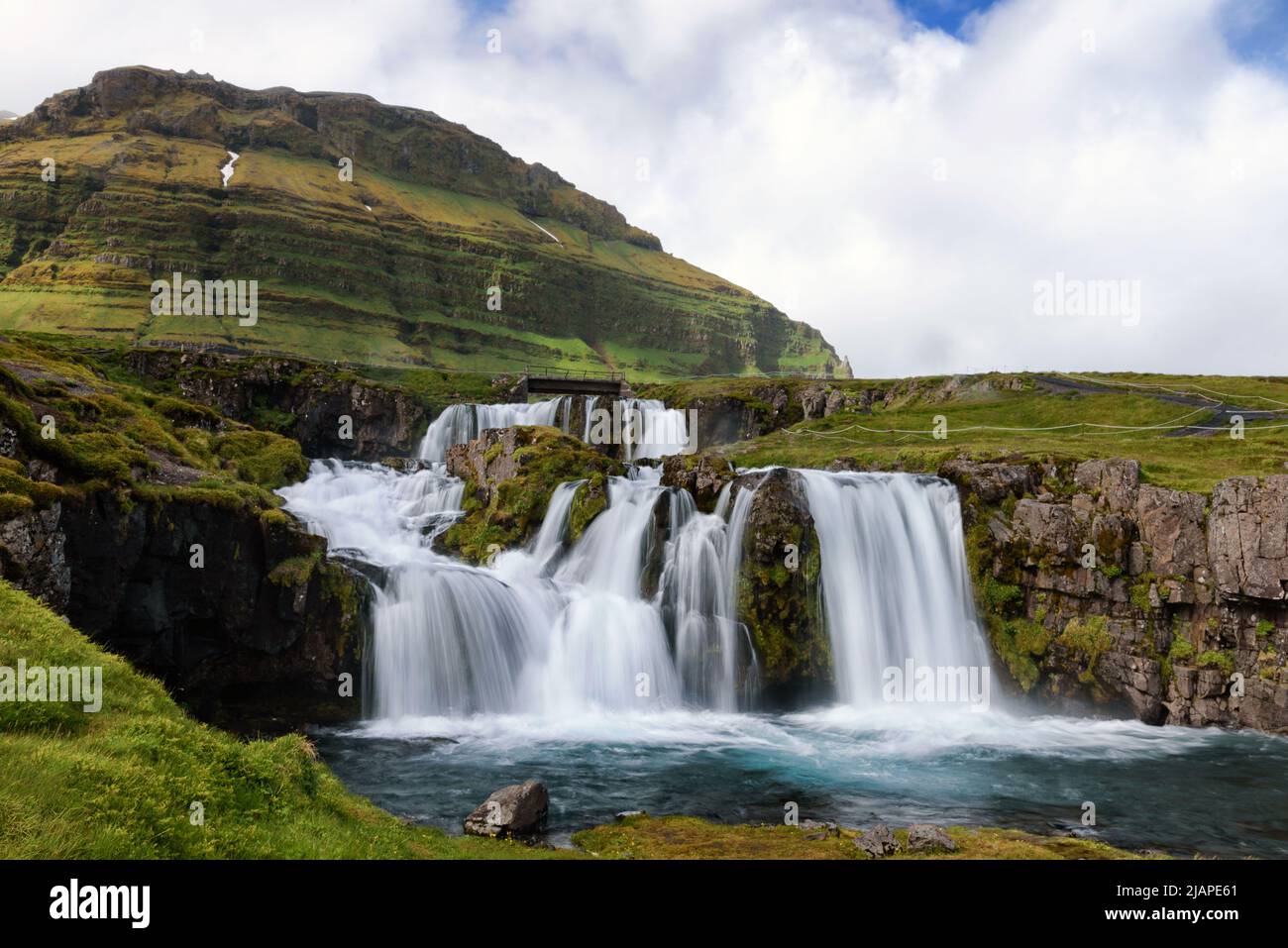 Kirkjufellsfoss. Punto di ritrovo fotografico con vista su una cascata iconica e sul monte a forma distintamente Kirkjufell, Islanda. Foto Stock