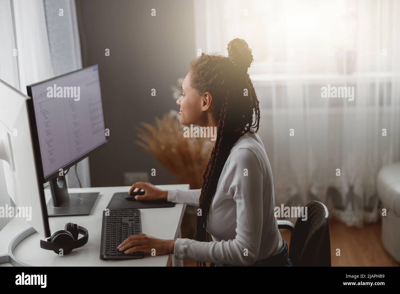 Giovane donna concenrated codificatore che lavora su computer a casa codifica java script algoritmo Foto Stock