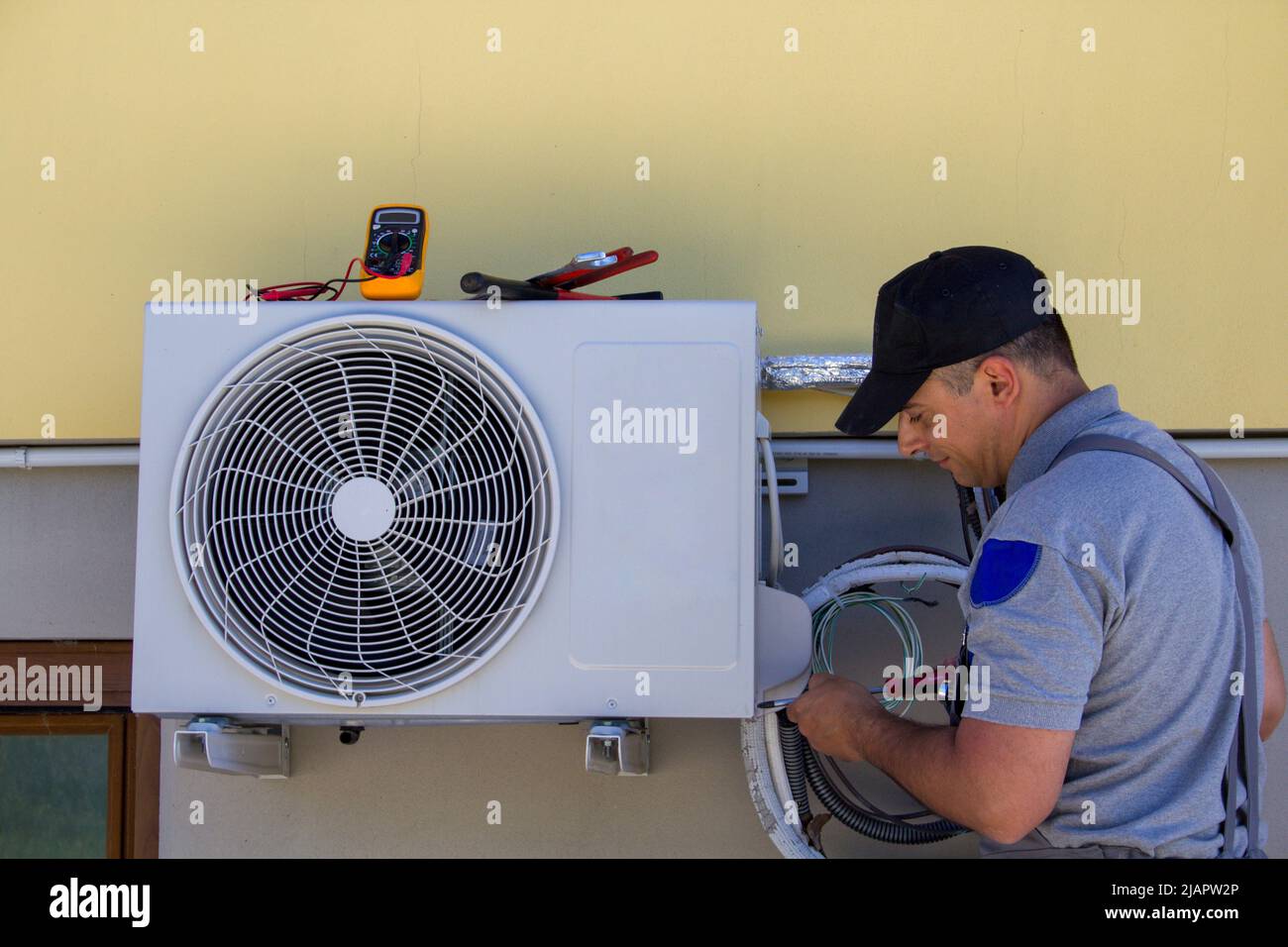 Foto di un idraulico che monta e ripara il motore di un condizionatore  d'aria domestico. Lavoro fai-da-te Foto stock - Alamy