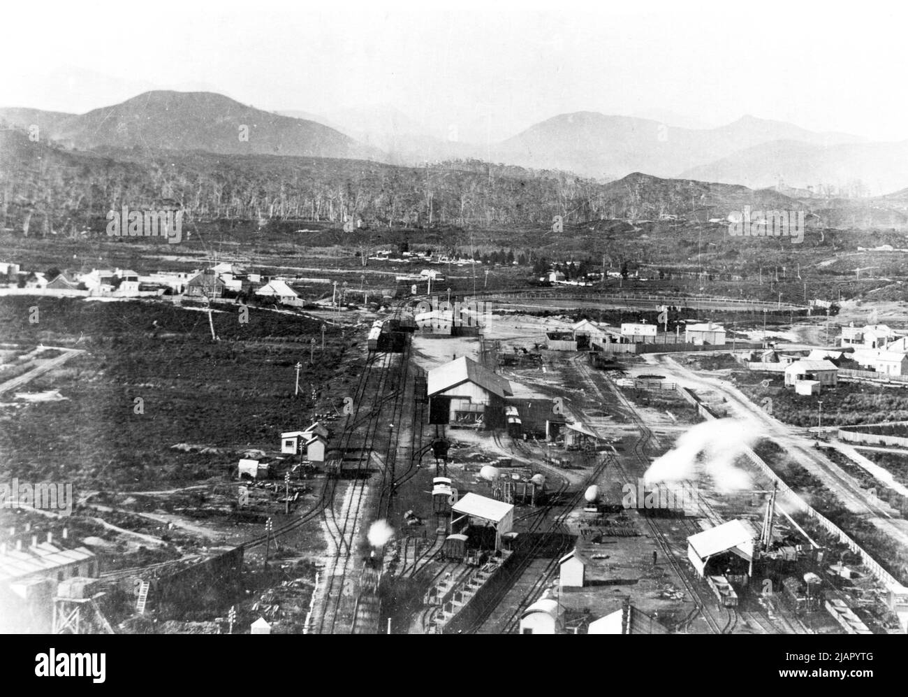 Una prima panoramica della stazione di Zeehan guardando a sud, che mostra le 3ft 6in linee della baia del Governo e dell'UEM nel centro con un treno EBR in arrivo e il 2ft metri North East Dundas Yards a destra ca. Probabilmente all'inizio del 1900s Foto Stock