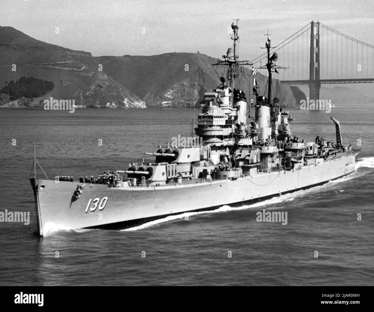 L'incrociatore pesante USS Bremerton della Marina degli Stati Uniti (CA-130) passando sotto il ponte Golden Gate, California (USA) ca. 1955 Foto Stock