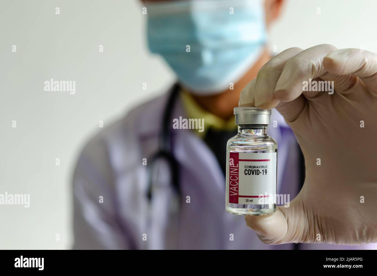 Medico o scienziato in possesso di una bottiglia di vaccino covido. Foto Stock