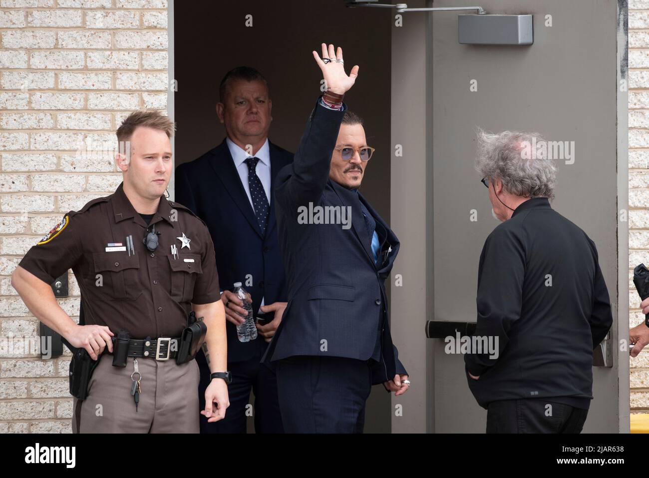 Johnny Depp ondeggia ai suoi fan durante una pausa nel suo processo civile con Amber sentito, al tribunale della contea di Fairfax, a Fairfax, Va., Venerdì, 27 maggio, 2022. Depp portò una causa di diffamazione contro la sua ex moglie, l'attrice Amber sentì, dopo che scrisse un op-ed nel Washington Post nel 2018 che, senza chiamare Depp, lo accusò di abuso domestico. Credito: Cliff Owen/CNP (RESTRIZIONE: NO New York o New Jersey Quotidiani o giornali entro un raggio di 75 miglia da New York City) Foto Stock