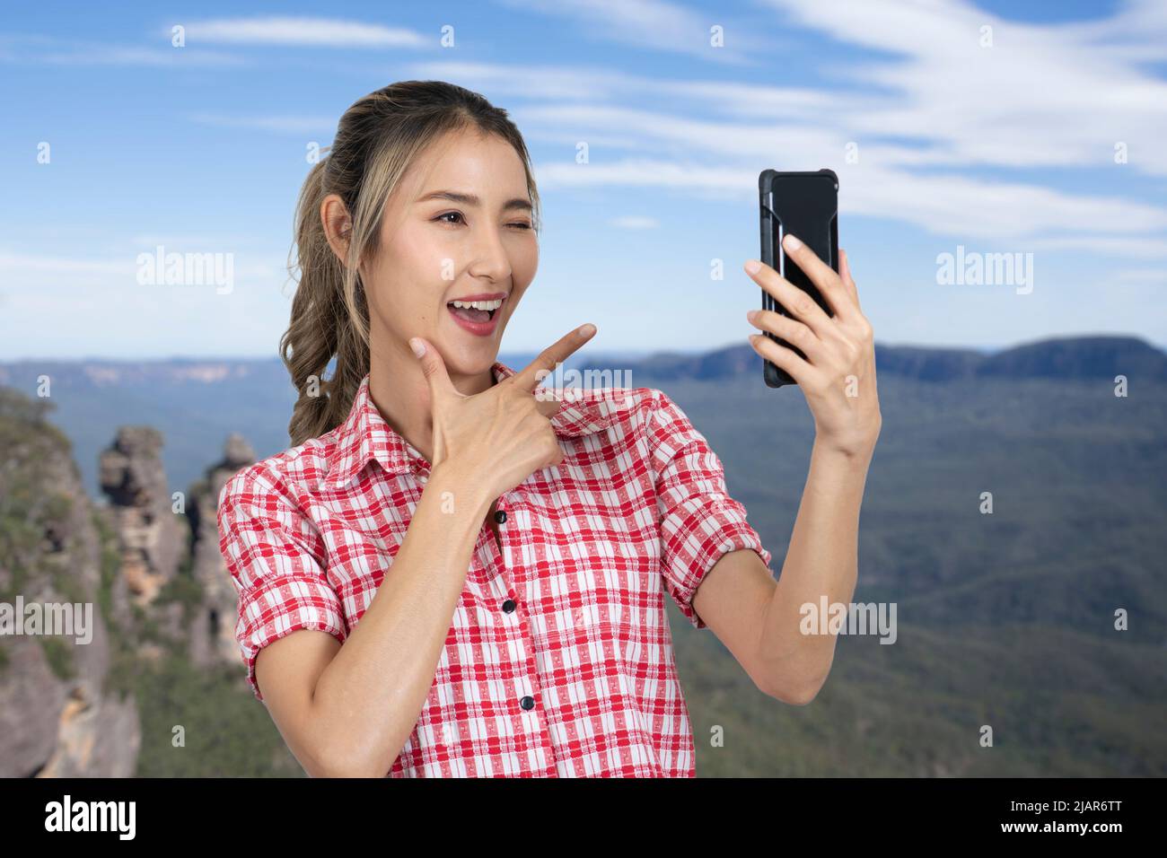 Le donne turisti amano prendere selfie in belle attrazioni naturali di montagna e cielo blu brillante. Foto Stock