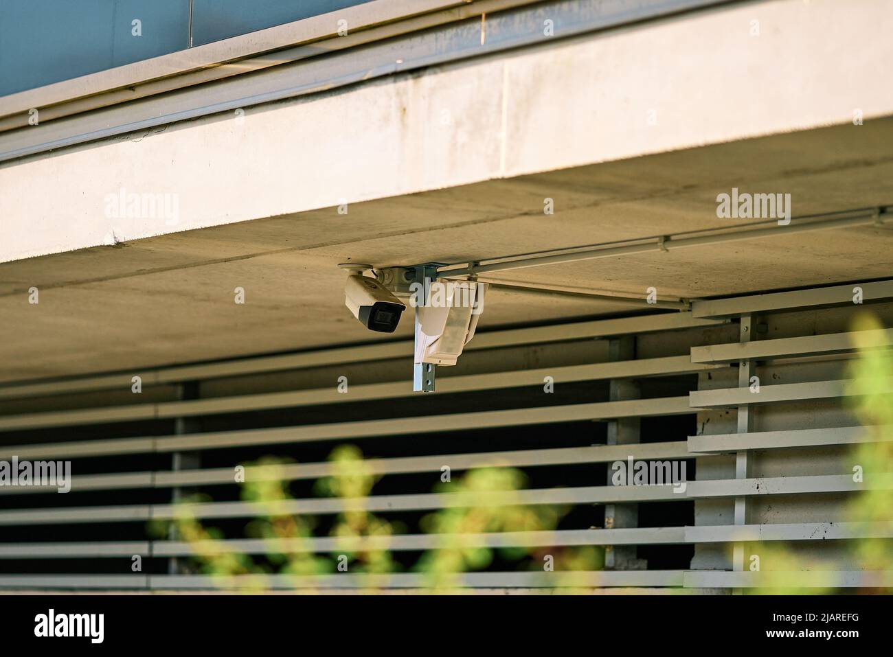 Telecamera di sicurezza e rilevatore di movimento posizionati sulla facciata di un edificio Foto Stock