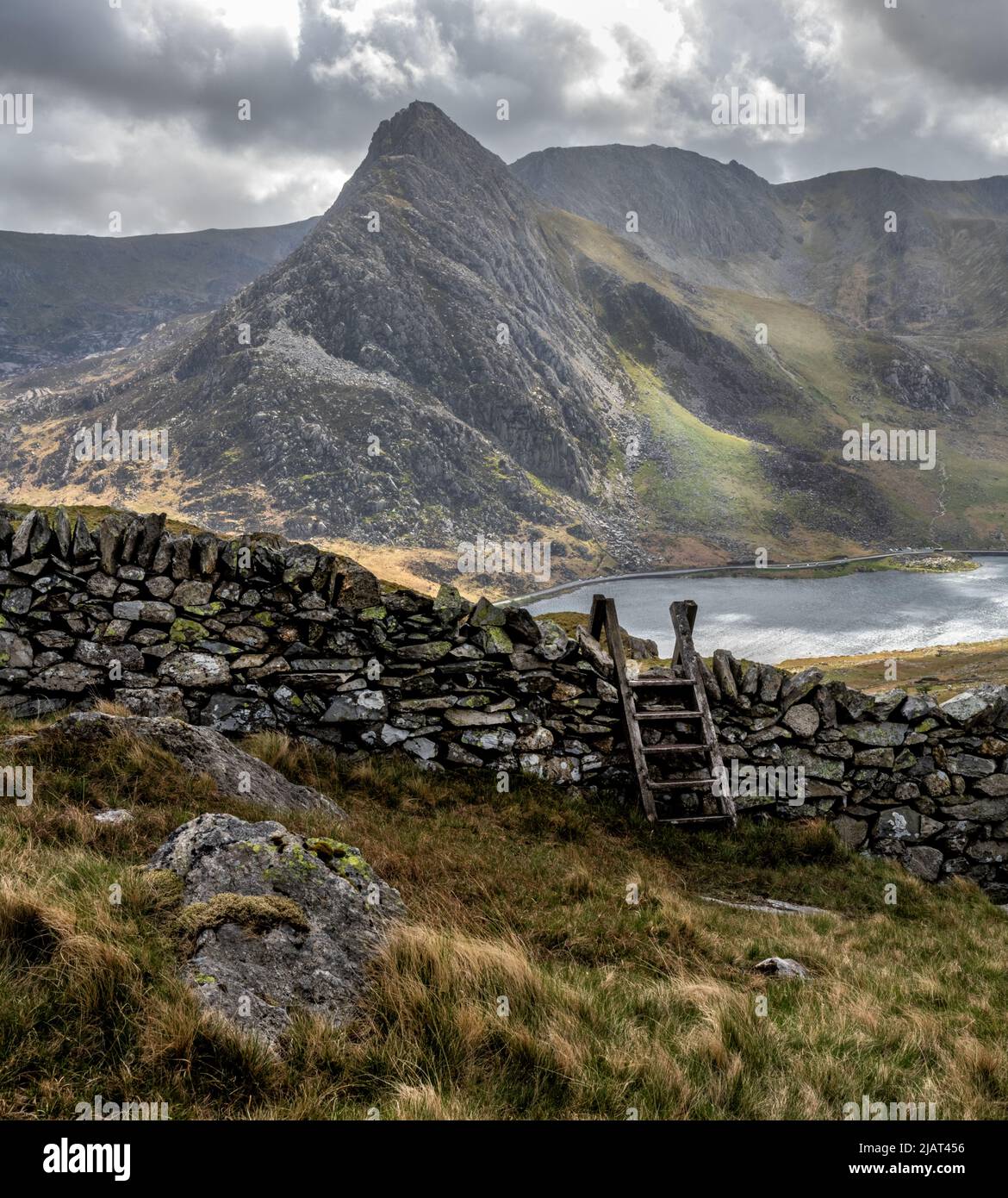 Snowdonia Landscape con Dry Stone Wall e Stile, Lago Ogwen e Tryfan Foto Stock