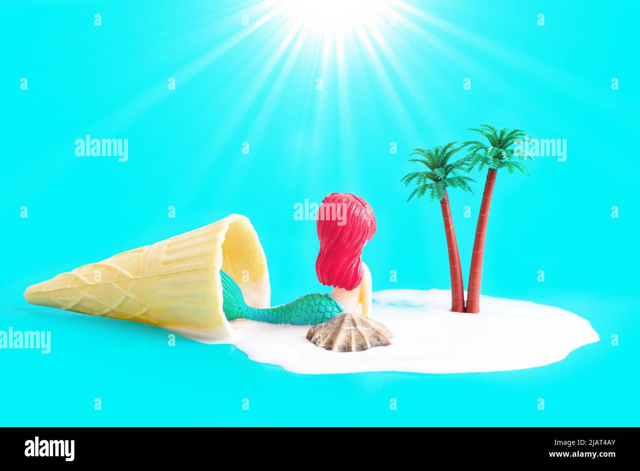 Figurina Mermaid godendo il sole su una spiaggia remota isola esotica coperta di schiuma di mare fatta di gelato fuso a cono di waffle. Destinazione estiva con Foto Stock