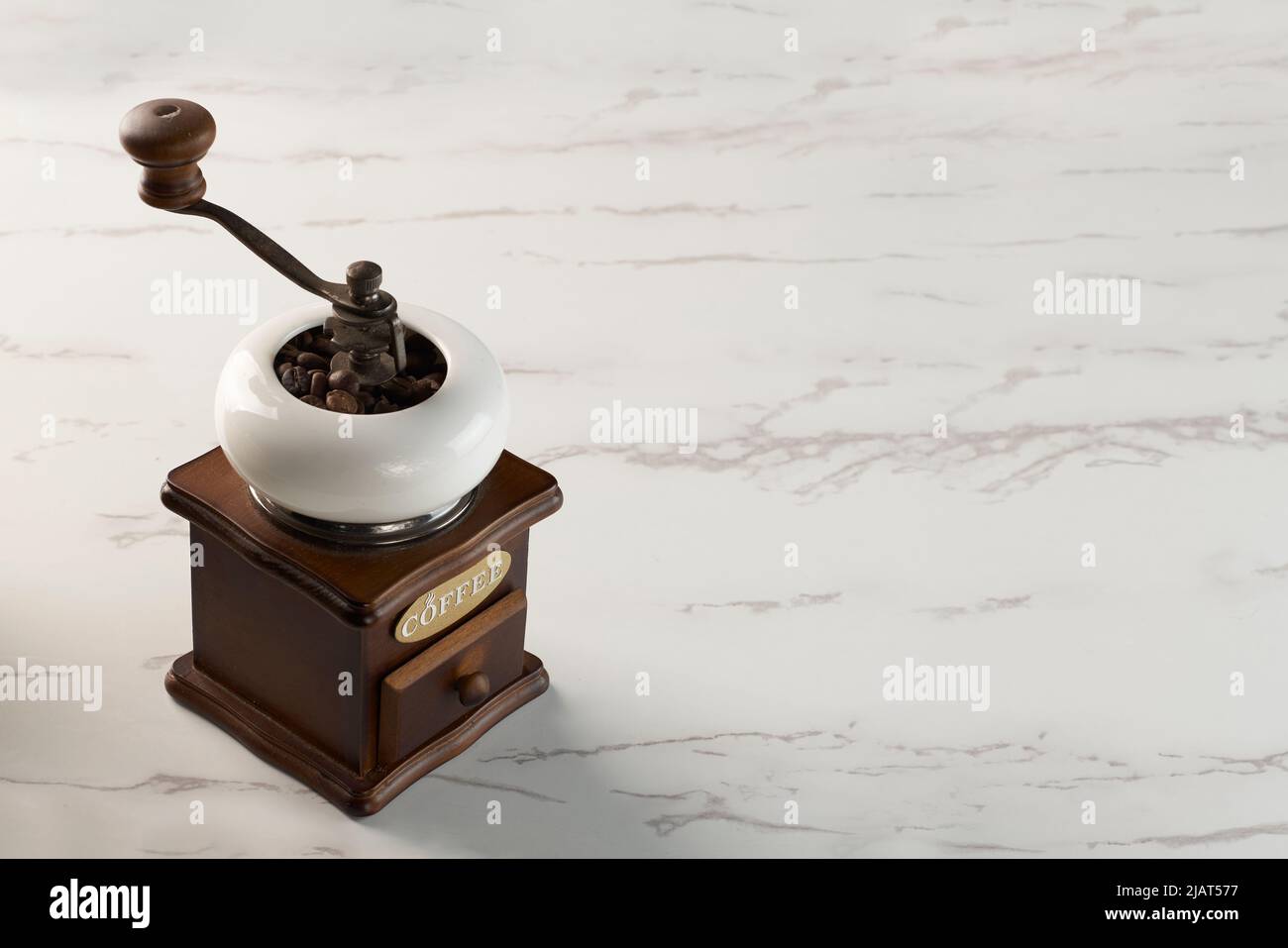 Un macinacaffè antico su un motivo di marmo. La parola 'coffee' contenuta nell'oggetto non è un nome commerciale, ma è un elemento grafico Foto Stock