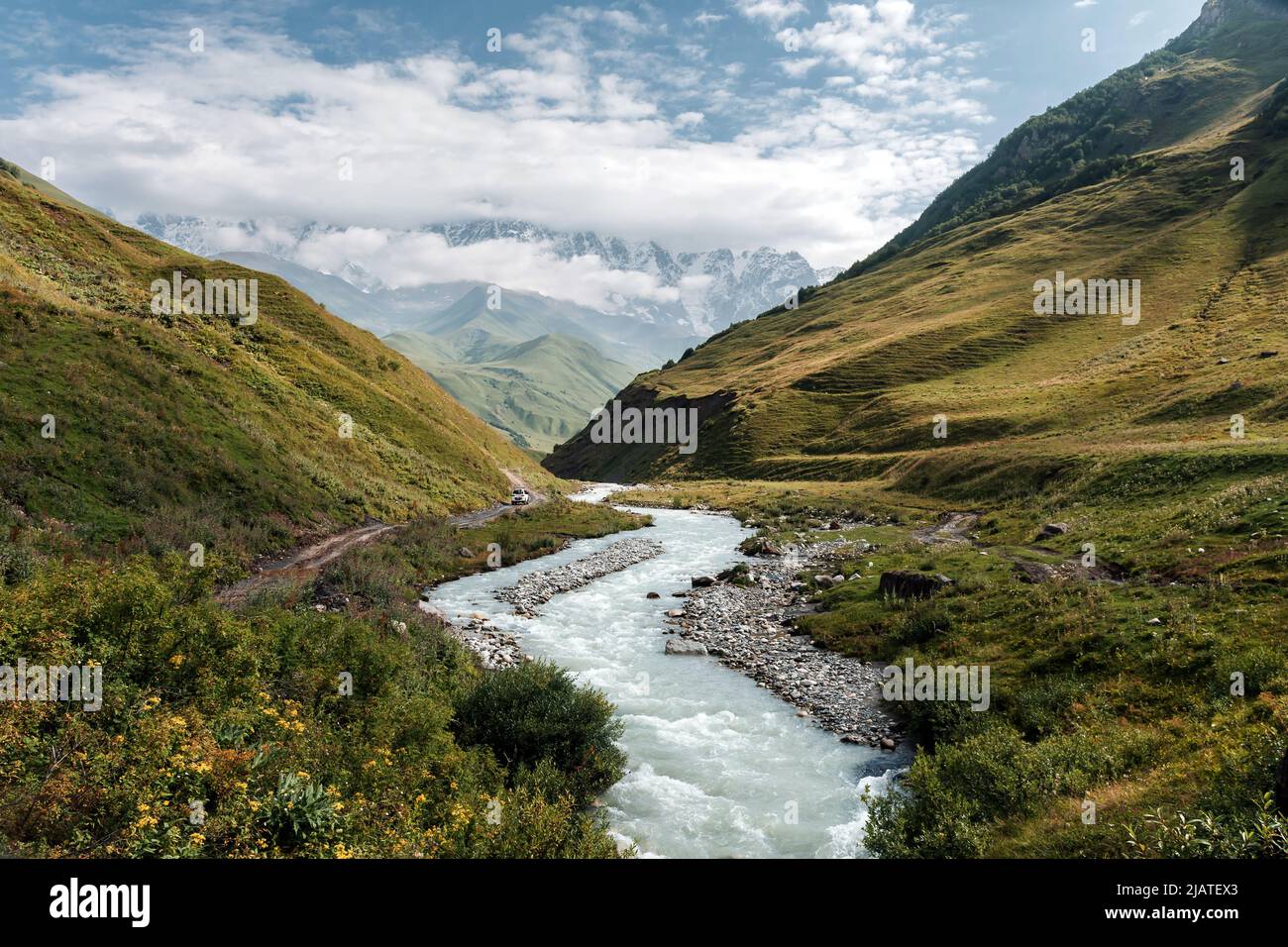 Bandiera nazionale georgiana con una vista incredibile sulla chiesa Lamaria nel villaggio Ushguli nella catena montuosa del Caucaso maggiore in Georgia, Svaneti Reg Foto Stock