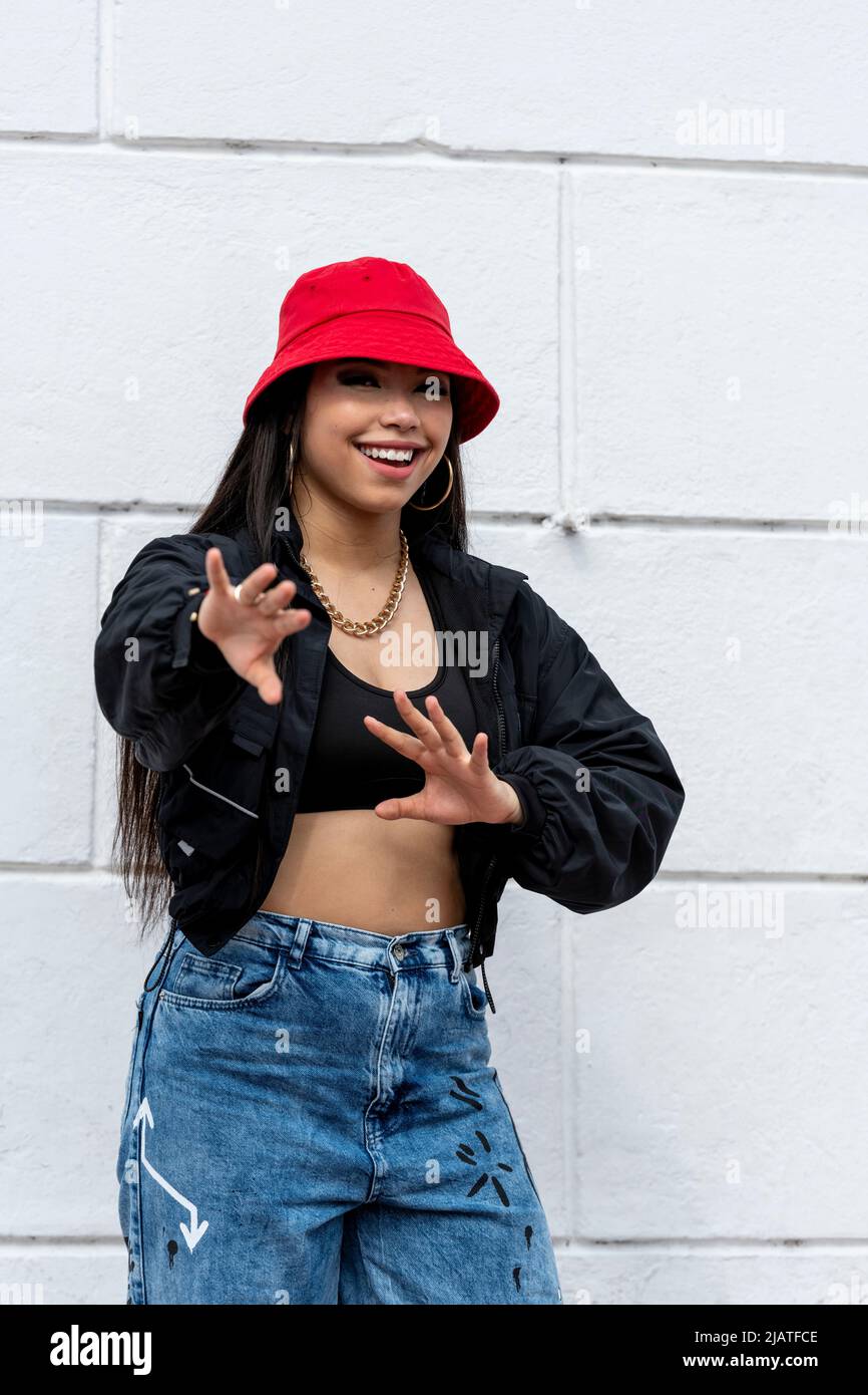 Giovane donna latina hip hop ballando in strada con un cappello rosso, Panama, America Centrale - foto di scorta Foto Stock