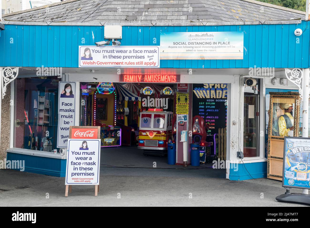 Sala giochi sul molo di Llandudno sulla costa del Galles del Nord con norme sui cartelli con maschera covid Foto Stock