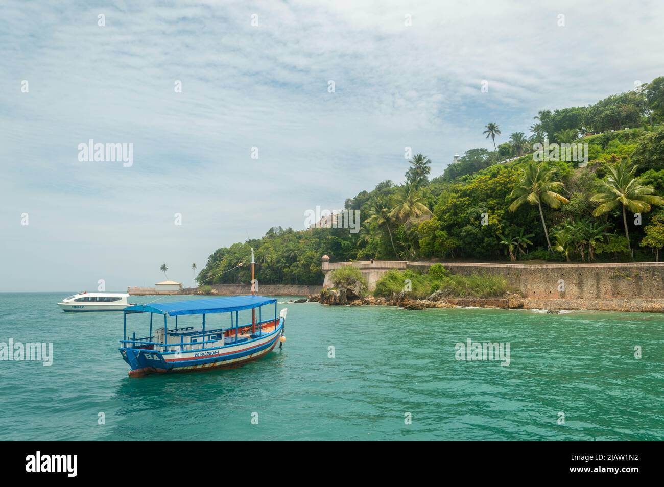 barca che arriva a una spiaggia murata Foto Stock