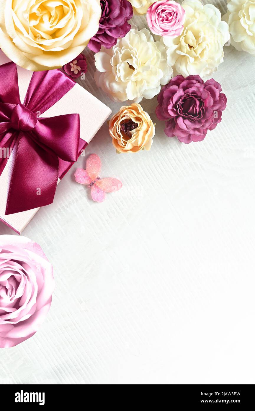 Rose colorate e confezione regalo su sfondo bianco. Bello, buono per le vacanze e regalo. Fiori modello. Foto Stock